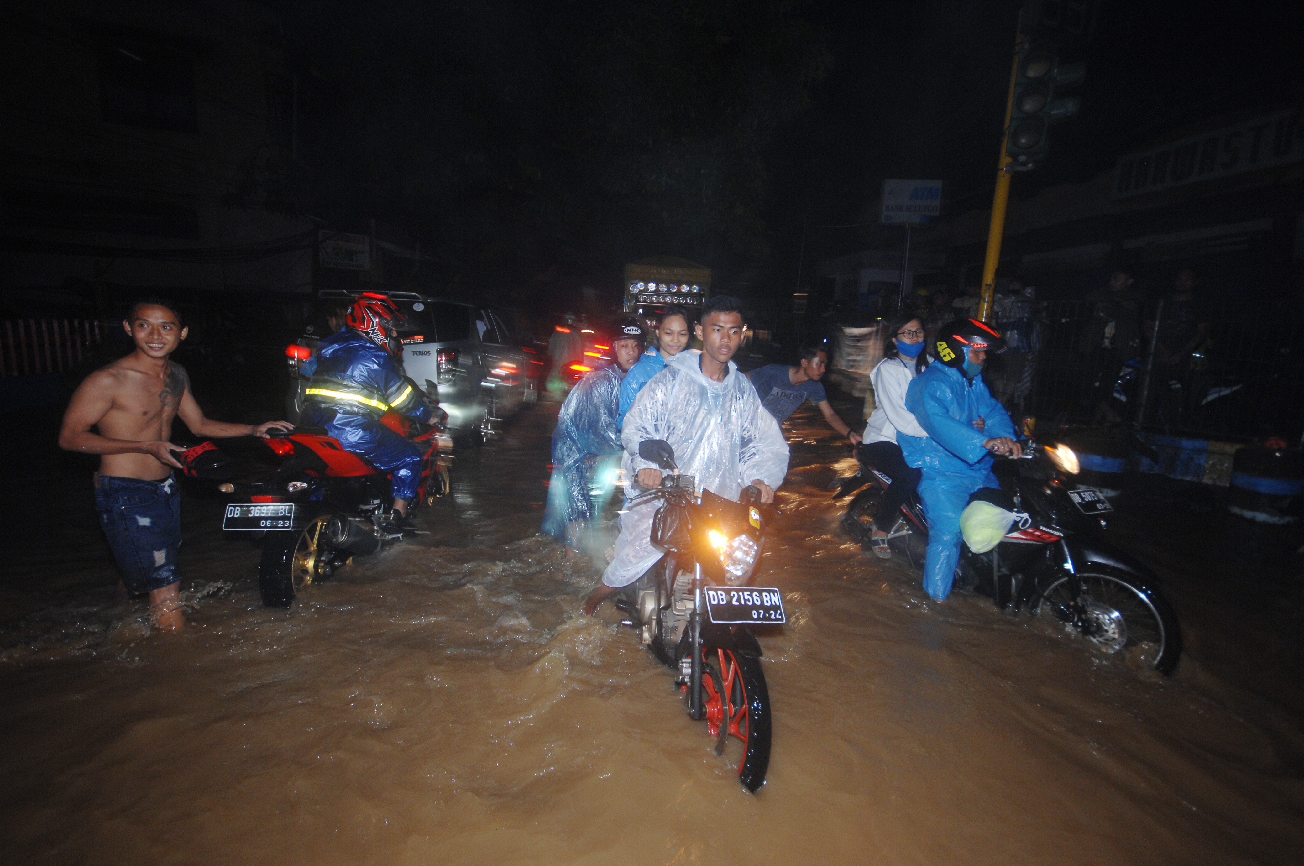 Warga menerobos banjir di salah satu ruas jalan di Kota Manado, Sulawesi Utara, Jumat (22/1/2021).