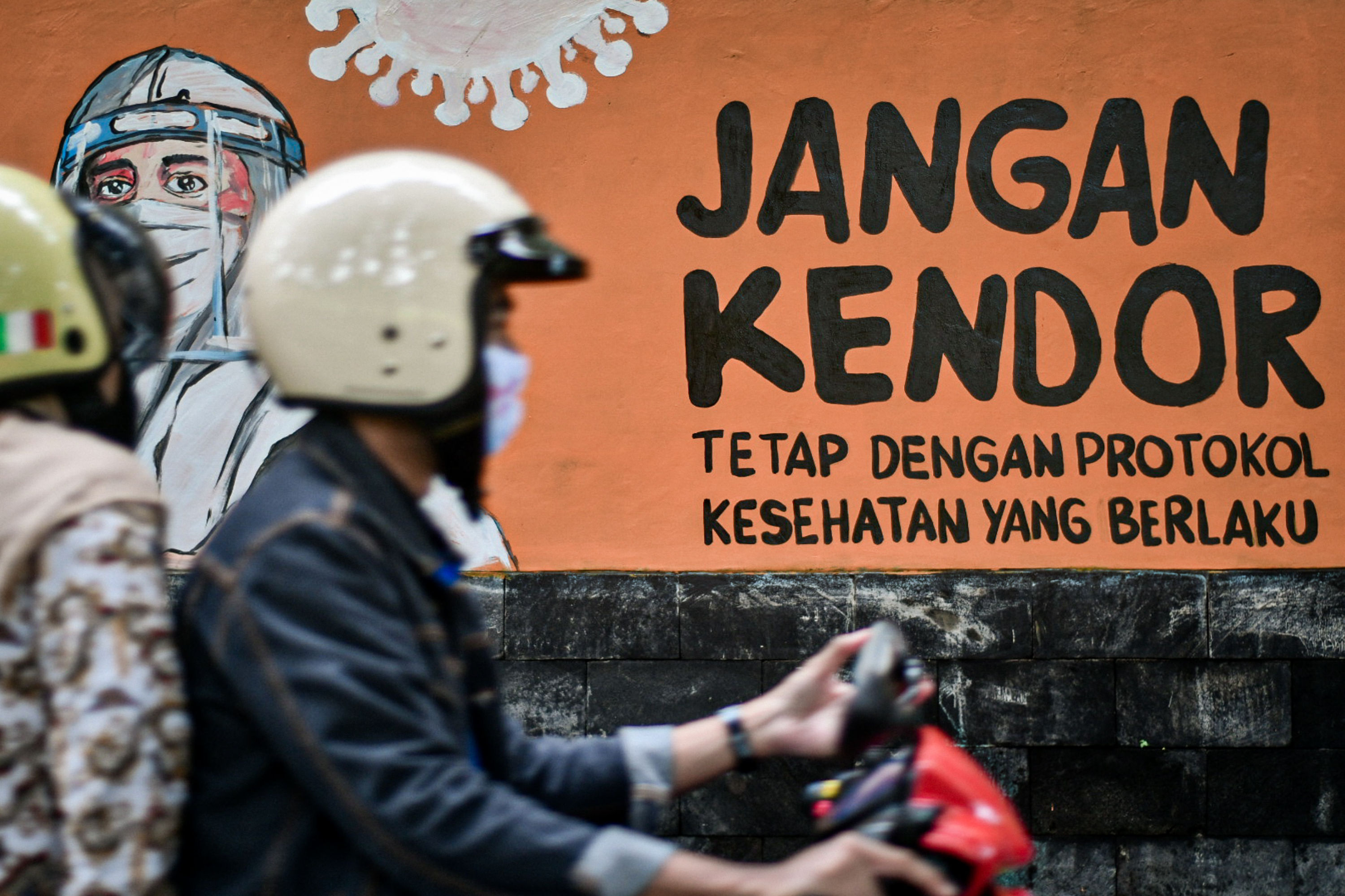 Warga melintasi mural bertema covid-19 di kantor Wali Kota Depok, Jawa Barat, Kamis (7/1).