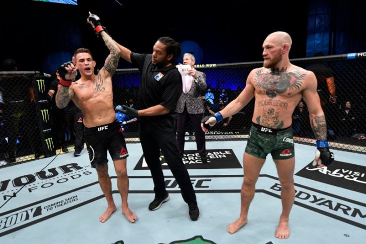 Wasit mengangkat tangan petarung AS Dustin Poirier (kiri) setelah memukul KO Conor McGregor pada laga UFC di Abu Dhabi, Minggu (24/1).