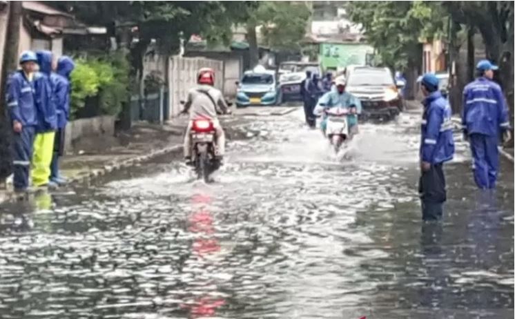 Pengendara melintas di genangan di Jalan Bujana Tirta Raya, Pisangan Timur, Jakarta Timur, Minggu (24/1).