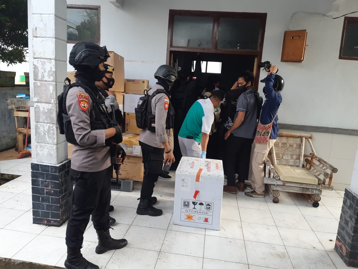 Ribuan dosis vaksin covid-19 Sinovac tiba di Bandara Sultan Baabullah, Ternate, dikawal aparat kepolisian, Senin (25/1).