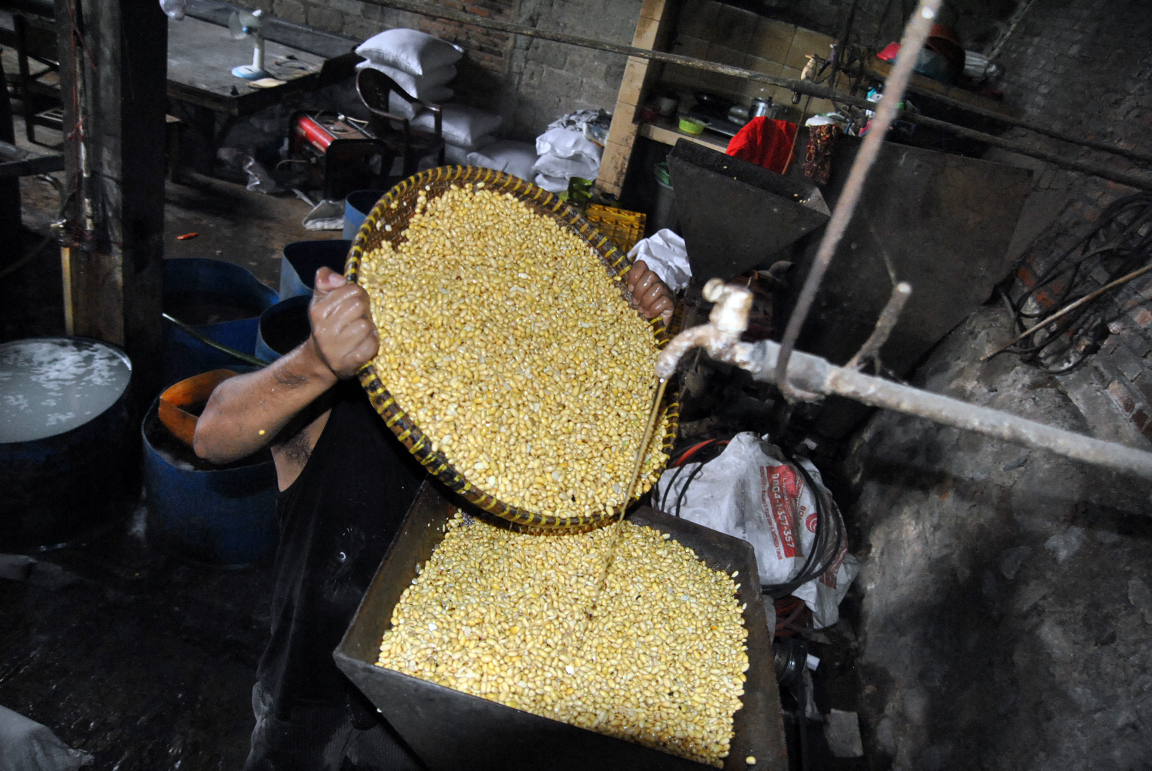 Pekerja mengangkat kedelai saat memproduksi tahu di wilayah Kelurahan Cilendek Barat, Bogor.