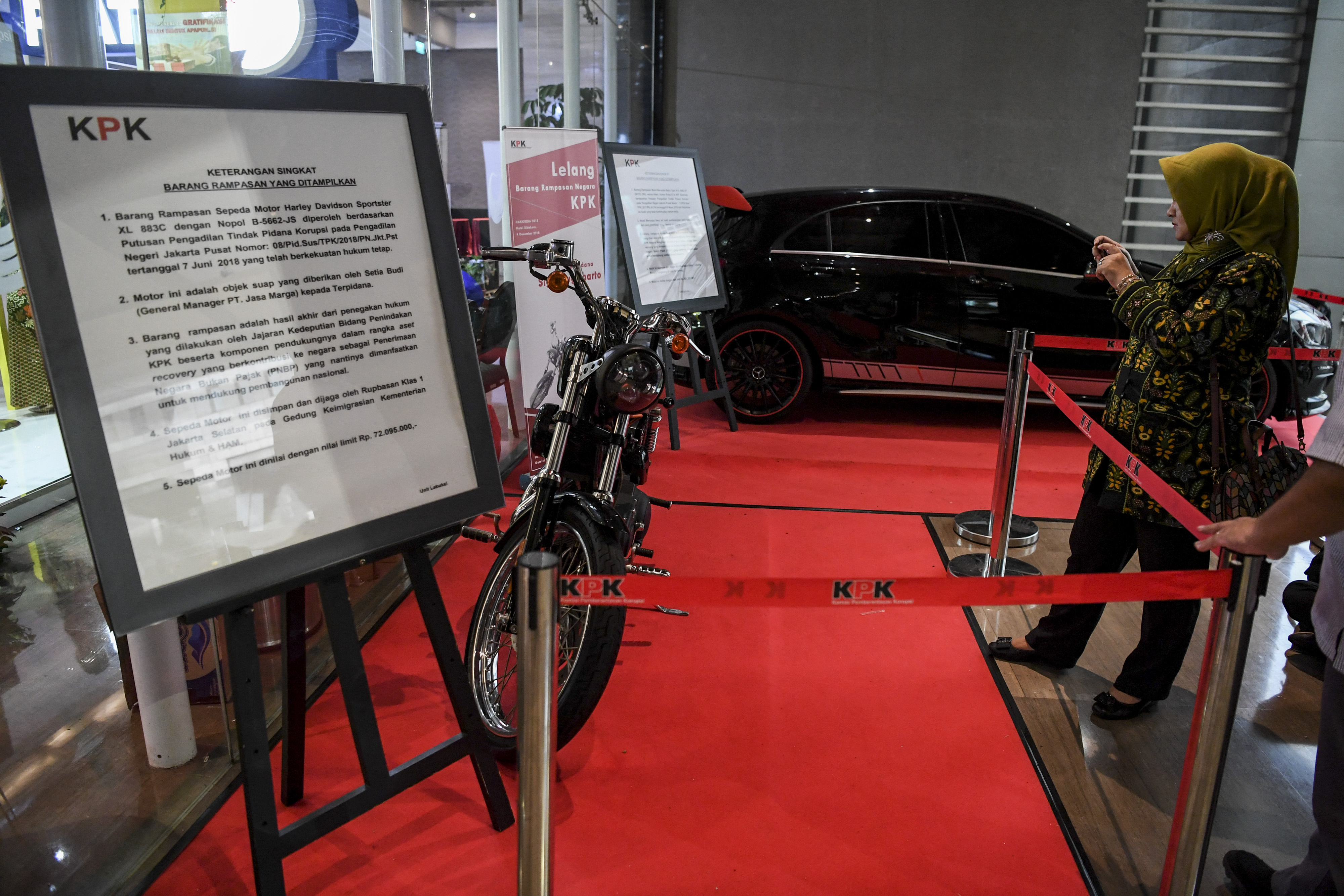 Warga mengambil gambar Motor Harley Davidson sitaan KPK yang dilelang secara daring di Hotel Bidakara, Jakarta.