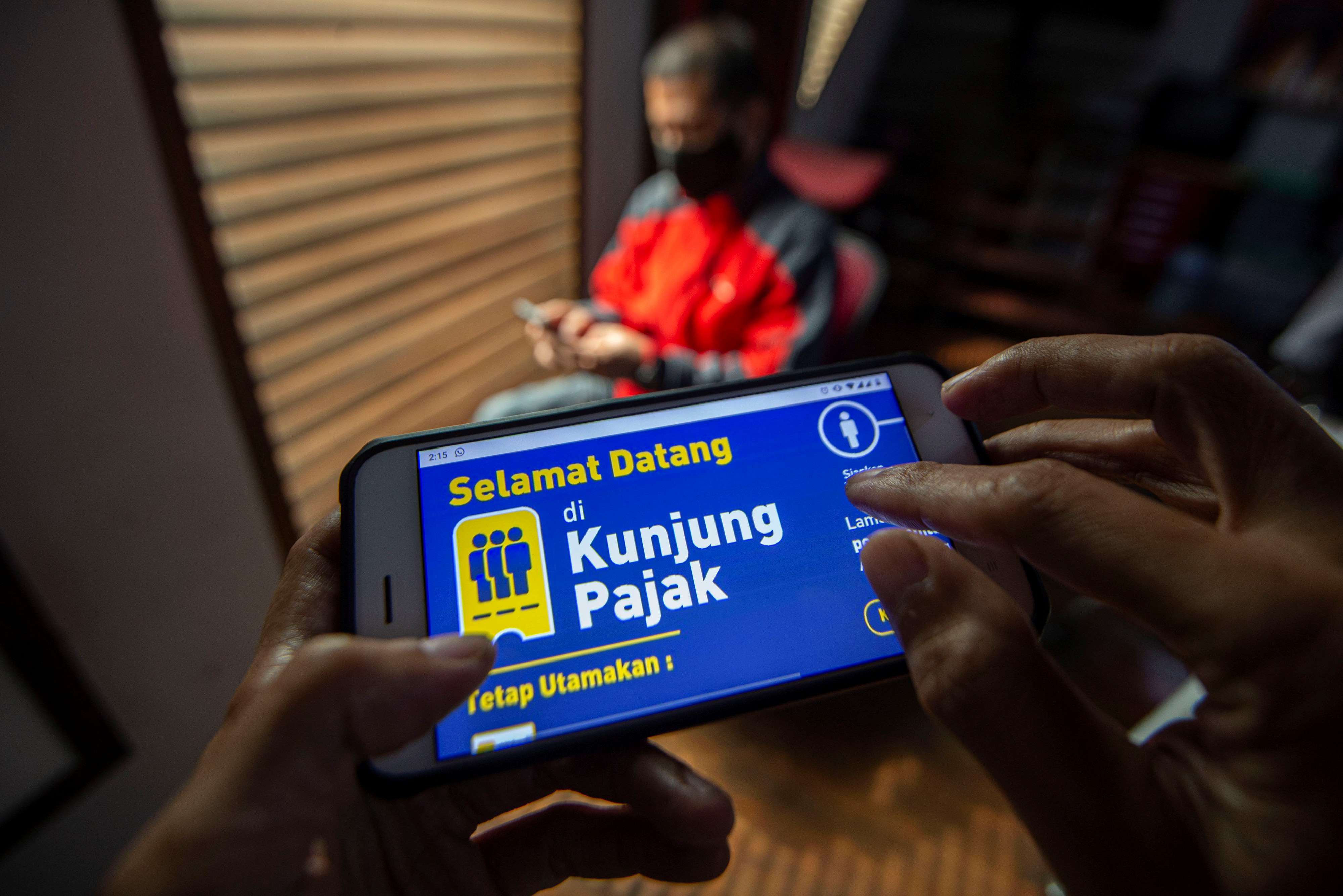 Warga mencari informasi tentang pajak di portal www.pajak.go.id dengan telepon pintarnya di Jakarta, beberapa waktu lalu.