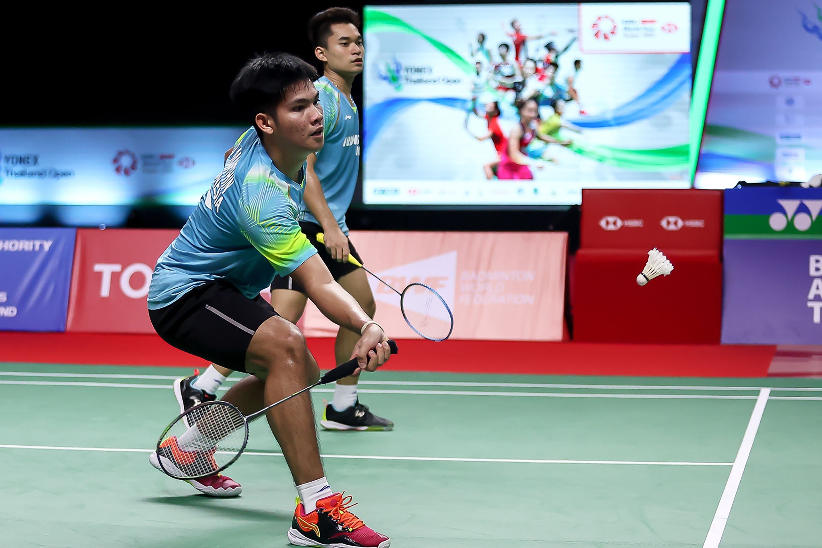 Leo Rolly Carnando melihat Daniel Marthin mengembalikan bola.