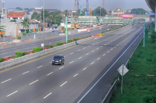 Kendaraan melintasi tol di daerah Cikunir, Bekasi, Jawa Barat, Minggu (12/4/2020)