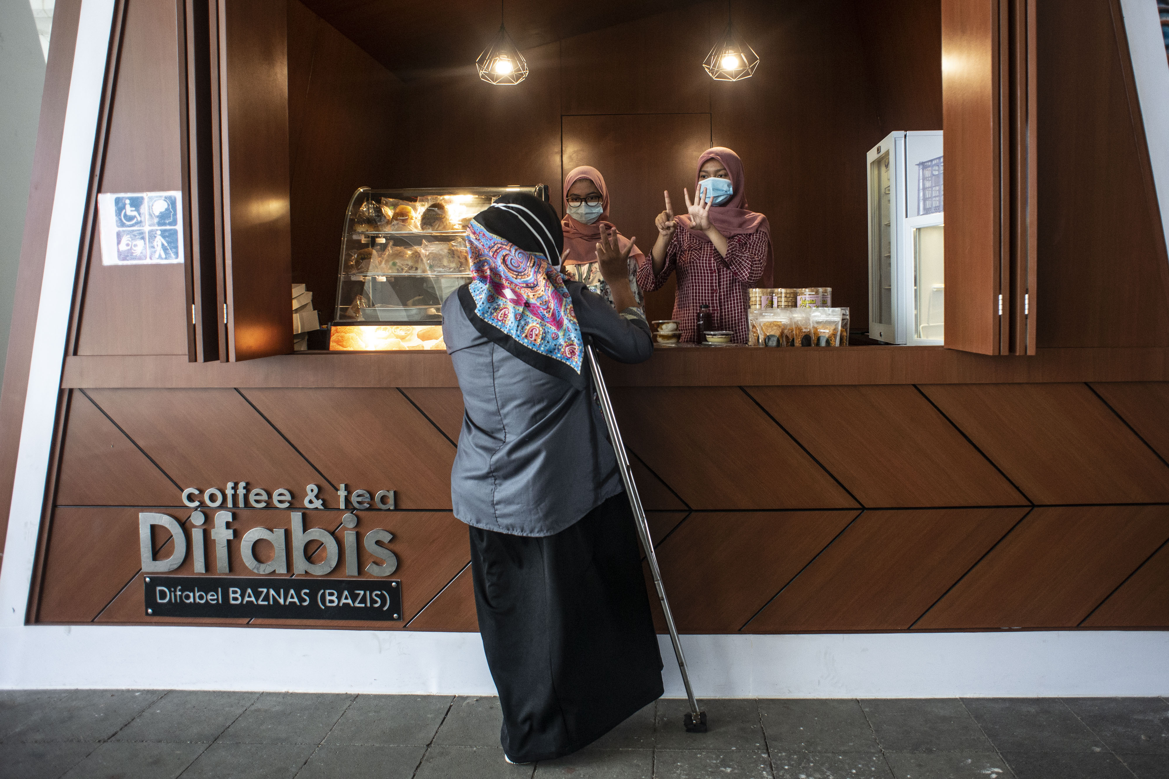 Pedagang disabilitas melayani pembeli di kedai Difabis Coffee & Tea, kawasan Terowongan Kendal, Jakarta Pusat, Selasa (26/1)