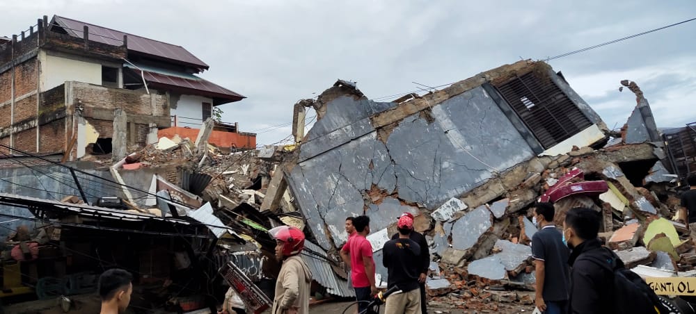 Petugas mengevakuasi korban yang terjepit dari bangunan yang runtuh akibat gempa bumi di Mamuju, Sulawesi Barat.