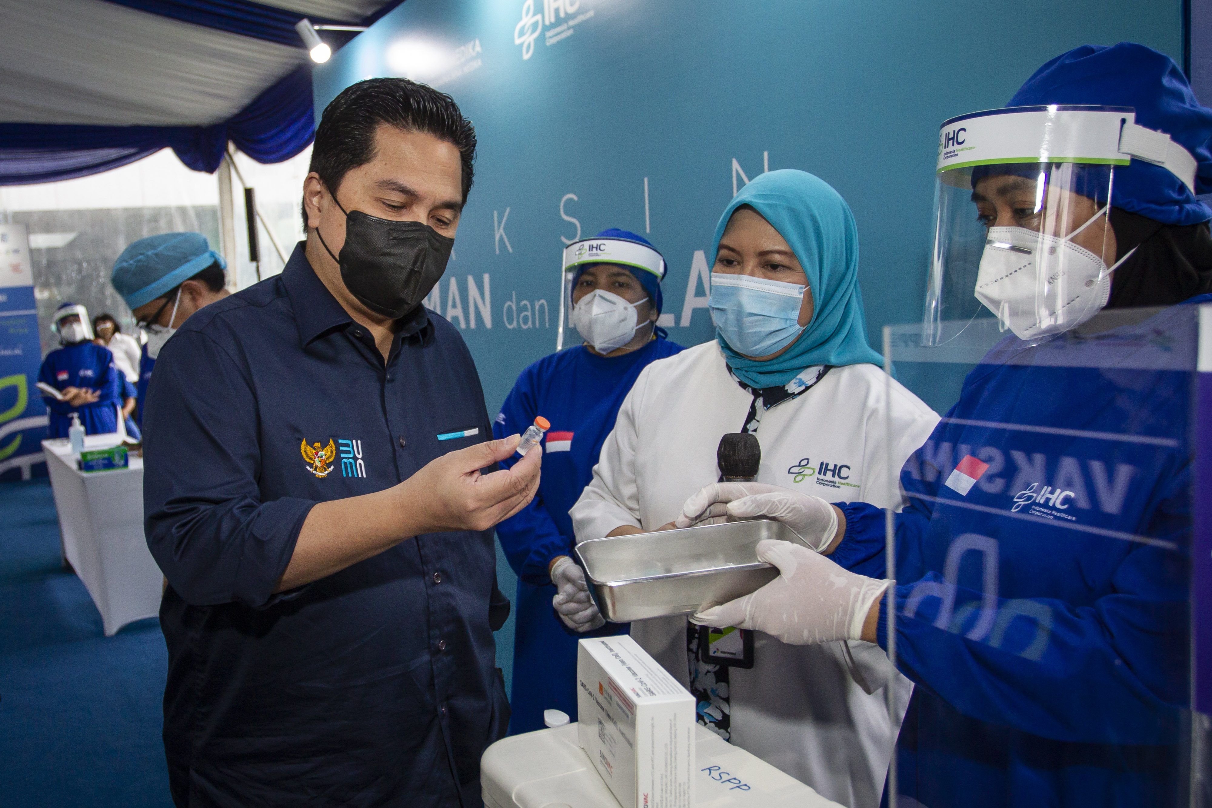 Menteri BUMN Erick Thohir memeriksa botol vaksin covid-19 buatan Sinovac. 