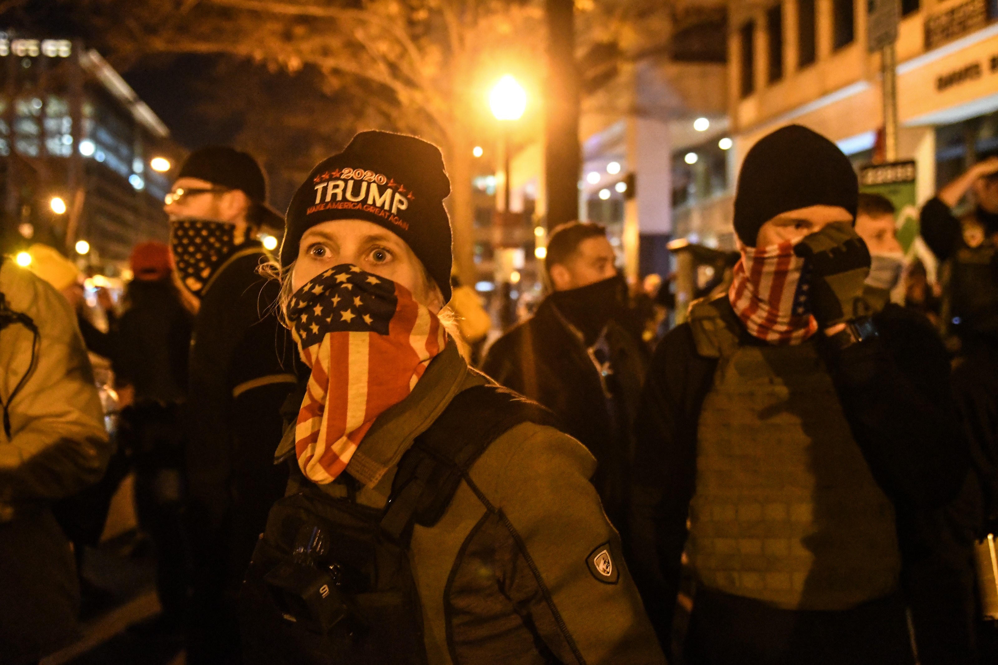 Seorang wanita dengan Proud Boys mengenakan bandana bendera Amerika selama protes pada 12 Desember 2020 di Washington DC.