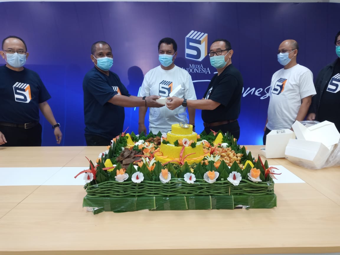 Dirut Media Indonesia Firdaus Dayat menyerahkan potongan tumpeng ke perwakilan karyawan pensiun, dalam syukuran HUT ke-51 Media Indonesia.