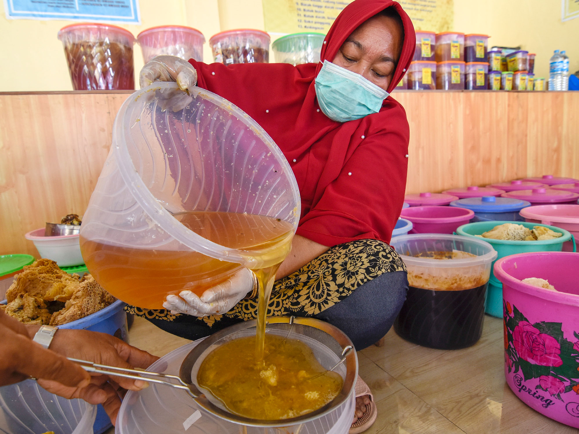 PRODUK UMKM MADU HUTAN SUMBAWA: Warga menyaring madu hutan Sumbawa sebelum dikemas di UM KM Madu Lestari Sumbawa di Desa Semongkat, 