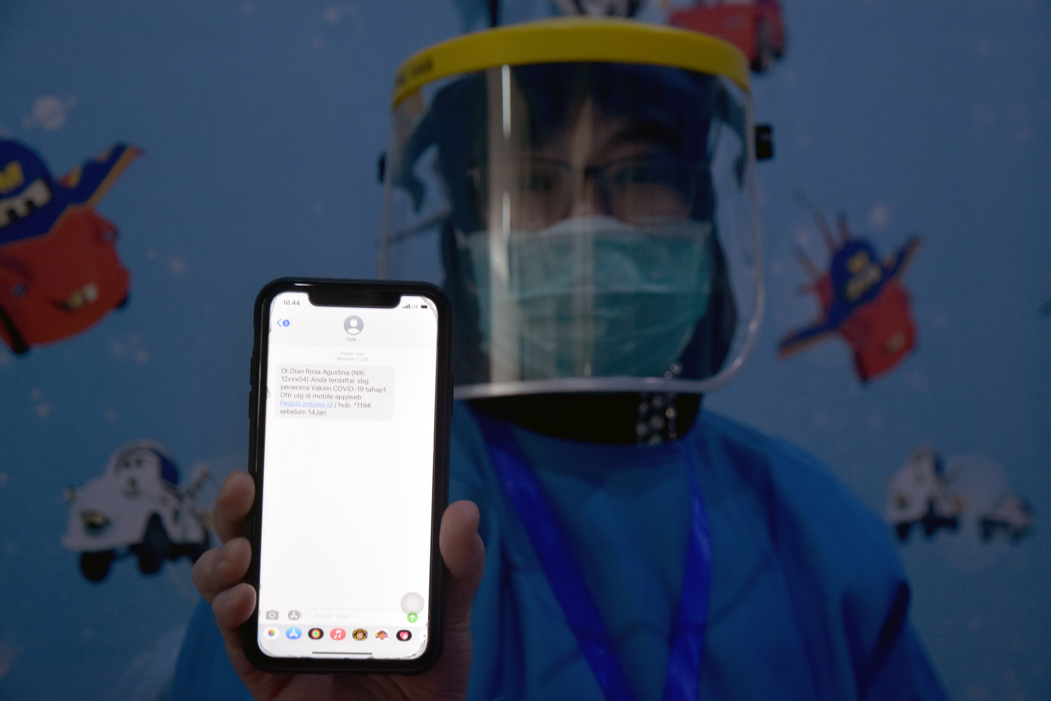 Seorang tenaga kesehatan Puskesmas Rejosari menunjukkan pesan singkat bahwa dirinya sudah terdata untuk menerima vaksin covid-19.