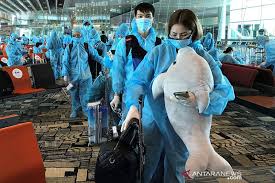 Seorang warga Vietnam membawa boneka binatang saat akan naik penerbangan repatriasi dari Singapura ke Vietnam di Bandara Changi, Singapura.