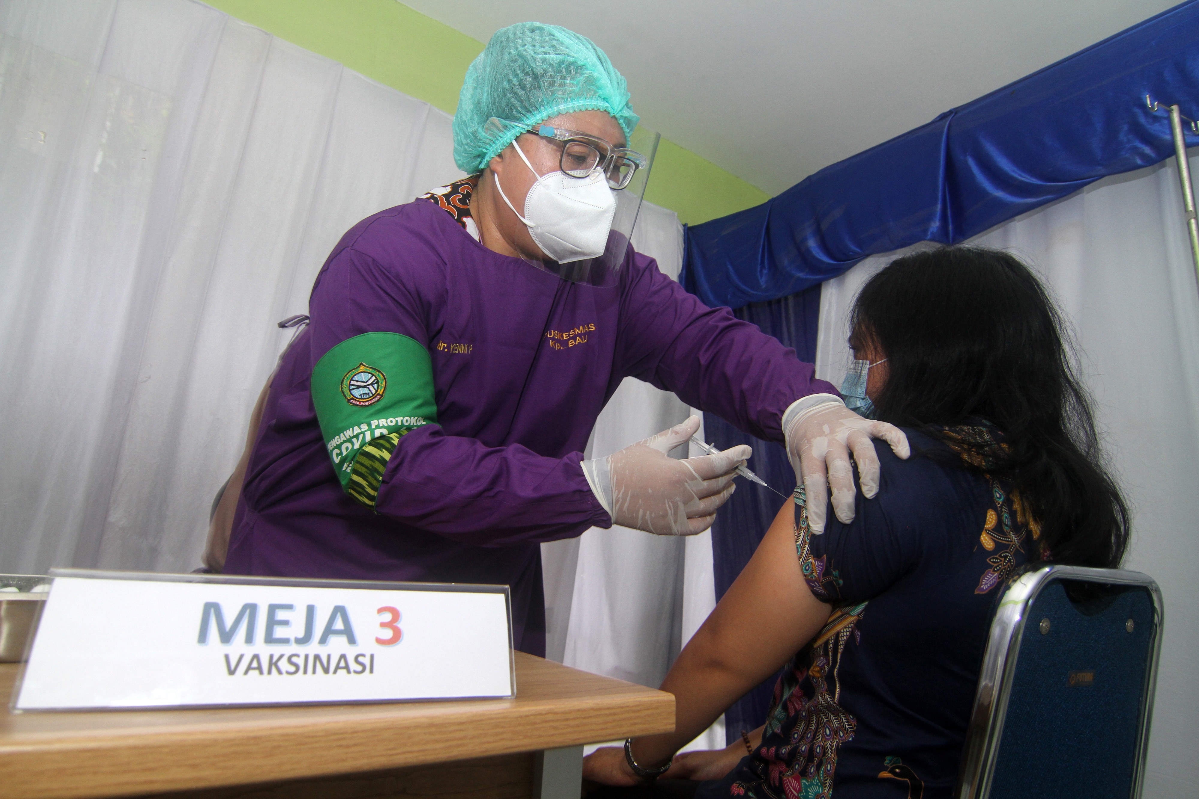 Petugas medis dr Yenny (kiri) melakukan simulasi vaksinasi covid-19 Sinovac kepada warga di Puskesmas Kampung Bali, Kalbar, Jumat (8/1).