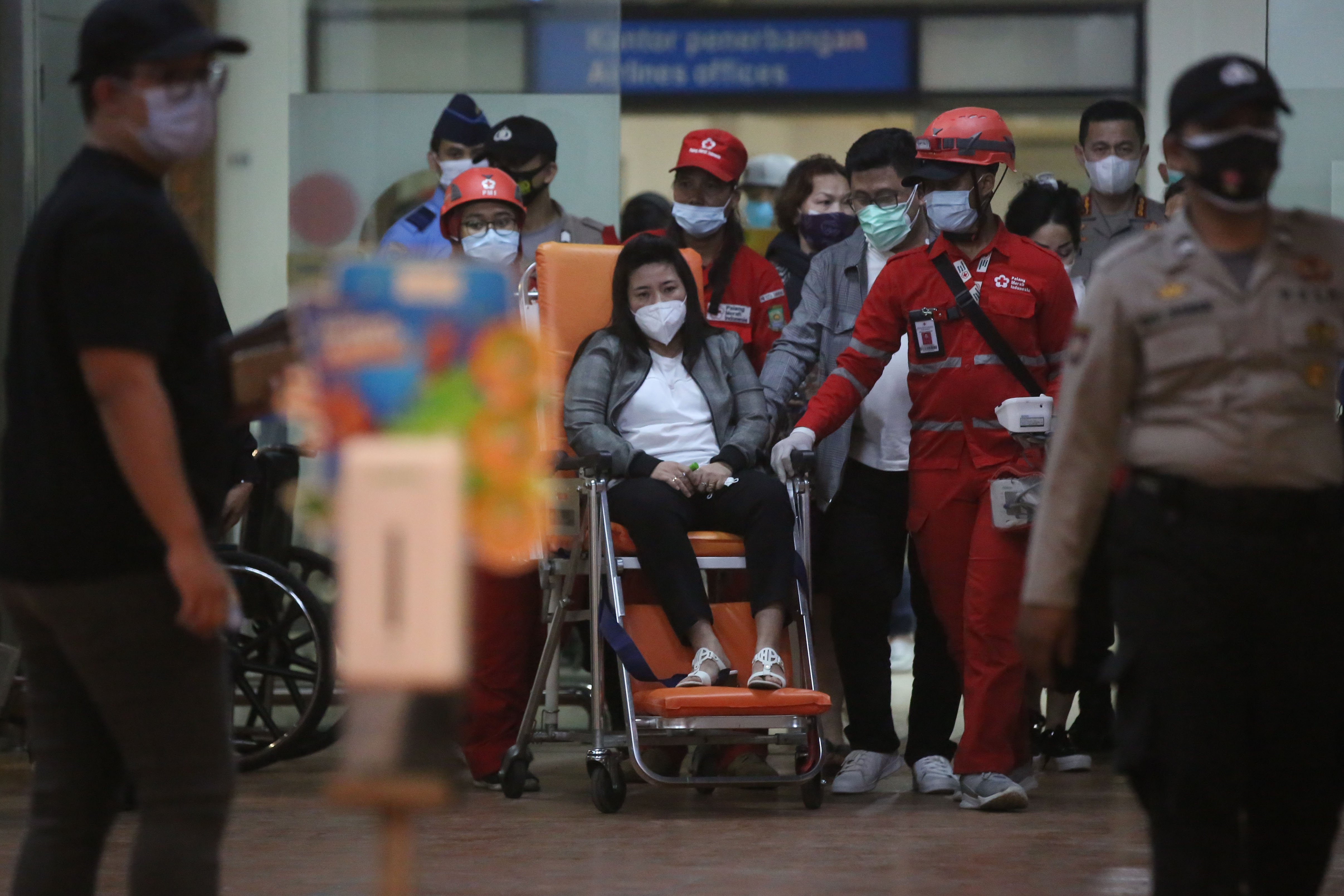 Petugas PMI mengantar keluarga korban seusai melapor di Posko krisis center pesawat Sriwijaya Air SJ 182, Bandara Soekarno Hatta.
