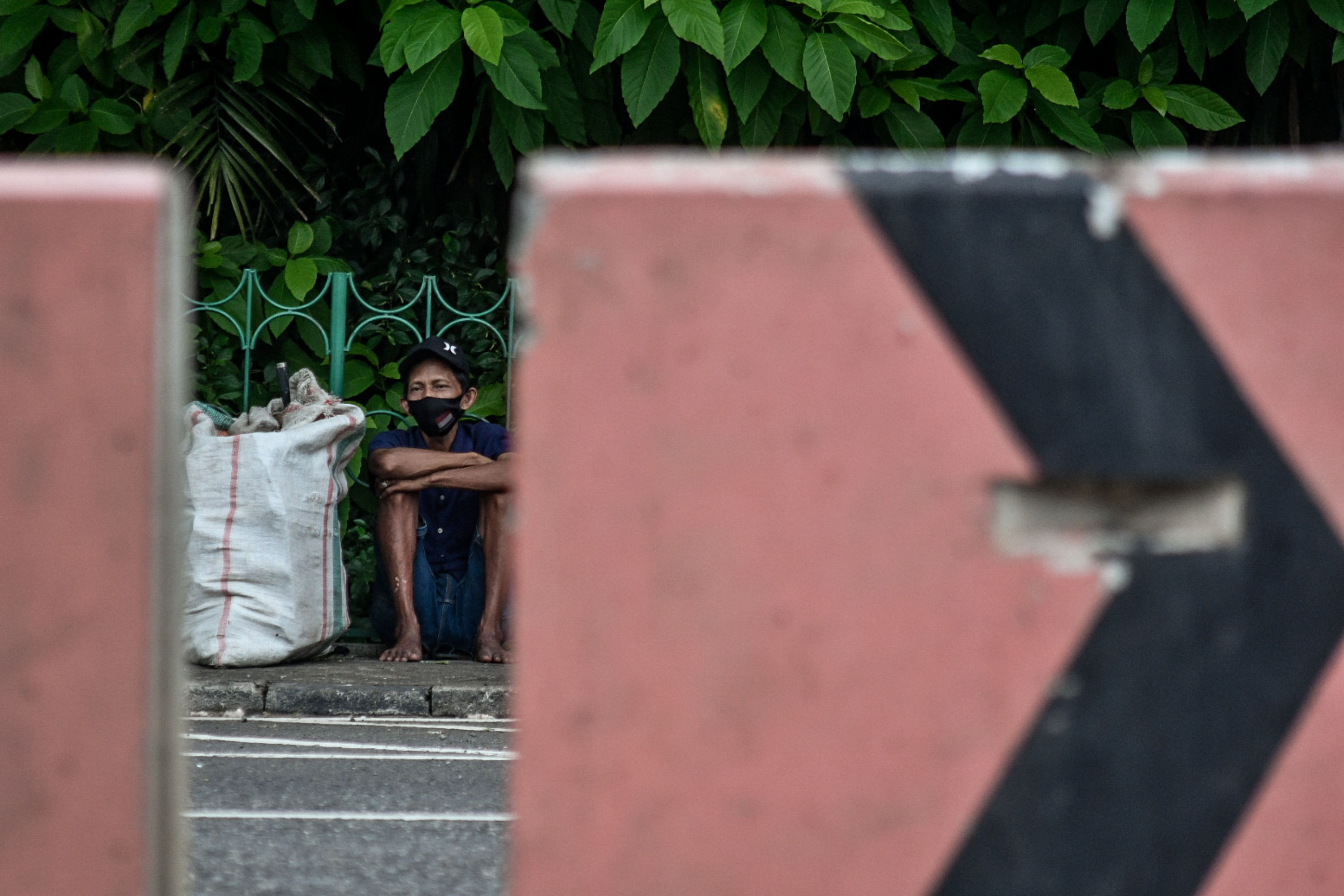 Penyandang Masalah Kesejahteraan Sosial (PMKS) sedang duduk di Kawasan Kuningan, Jakarta.