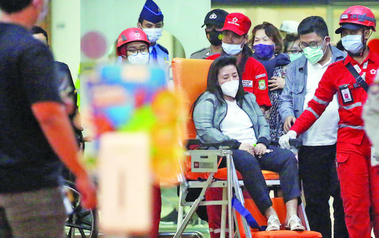 DATANGI CRISIS CENTER: Petugas PMI membantu keluarga korban yang sedih seusai melapor di posko crisis center pesawat Sriwijaya Air SJ-182  