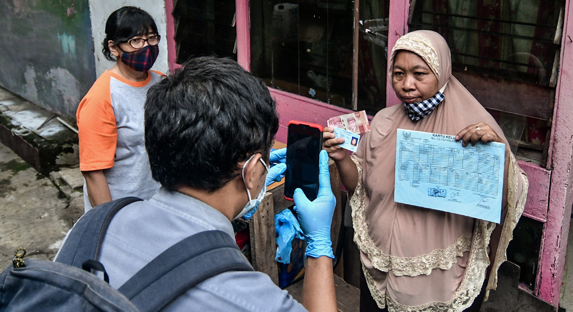 Petugas dari Pos Indonesia menyalurkan bansos tunai Rp300 ribu kepada warga RW 05, Kenari , Jakarta.