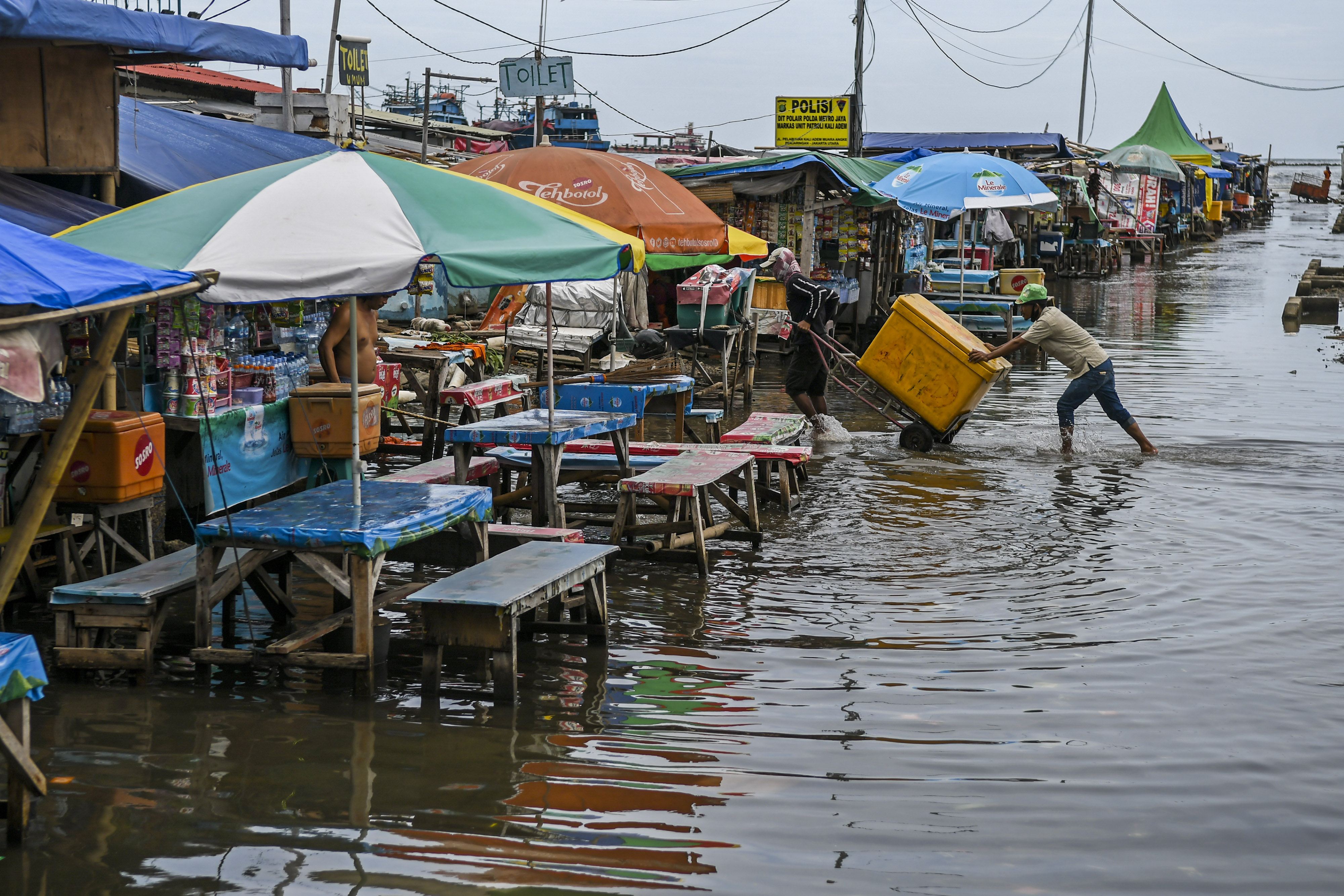 Warga beraktivitas saat banjir rob di Pelabuhan Kali Adem, Muara Angke, Jakarta.