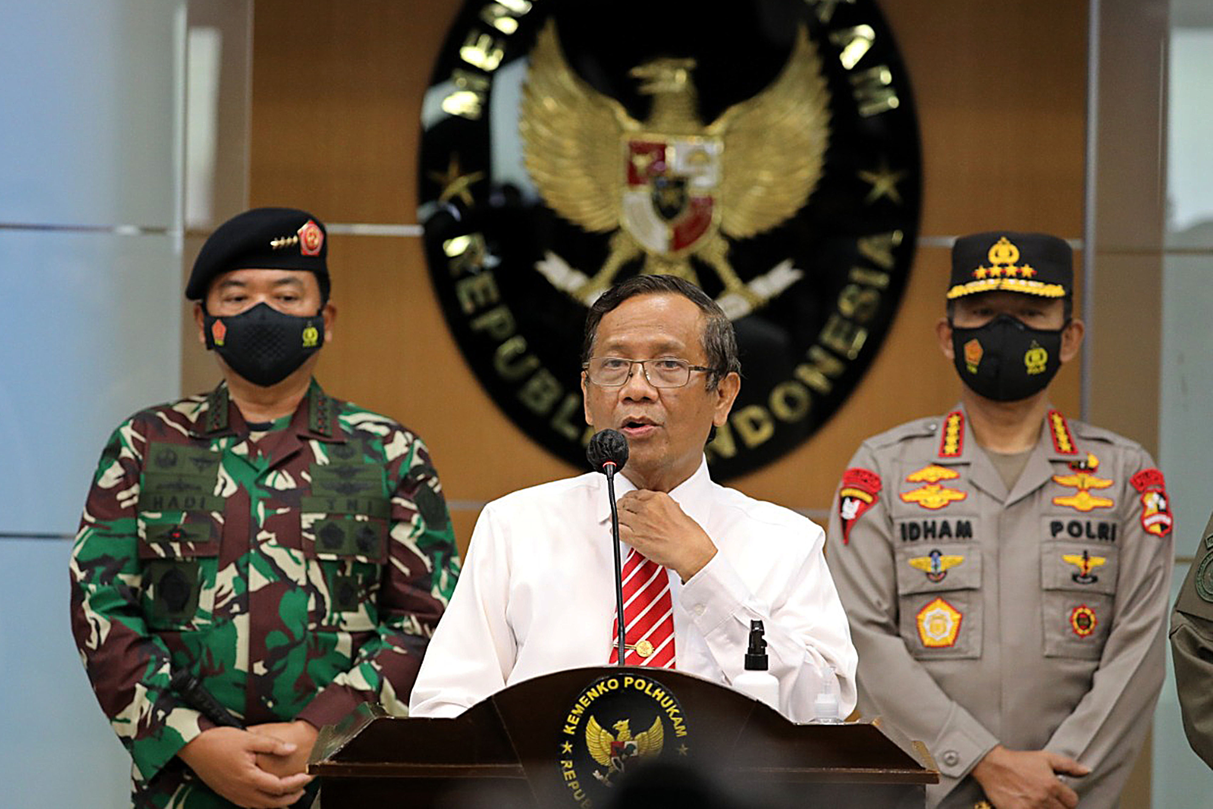 Menko Polhukam Mahfud MD (tengah) mengumumkan penghentian segala kegiatan Front Pembela Islam (FPI) di Jakarta.