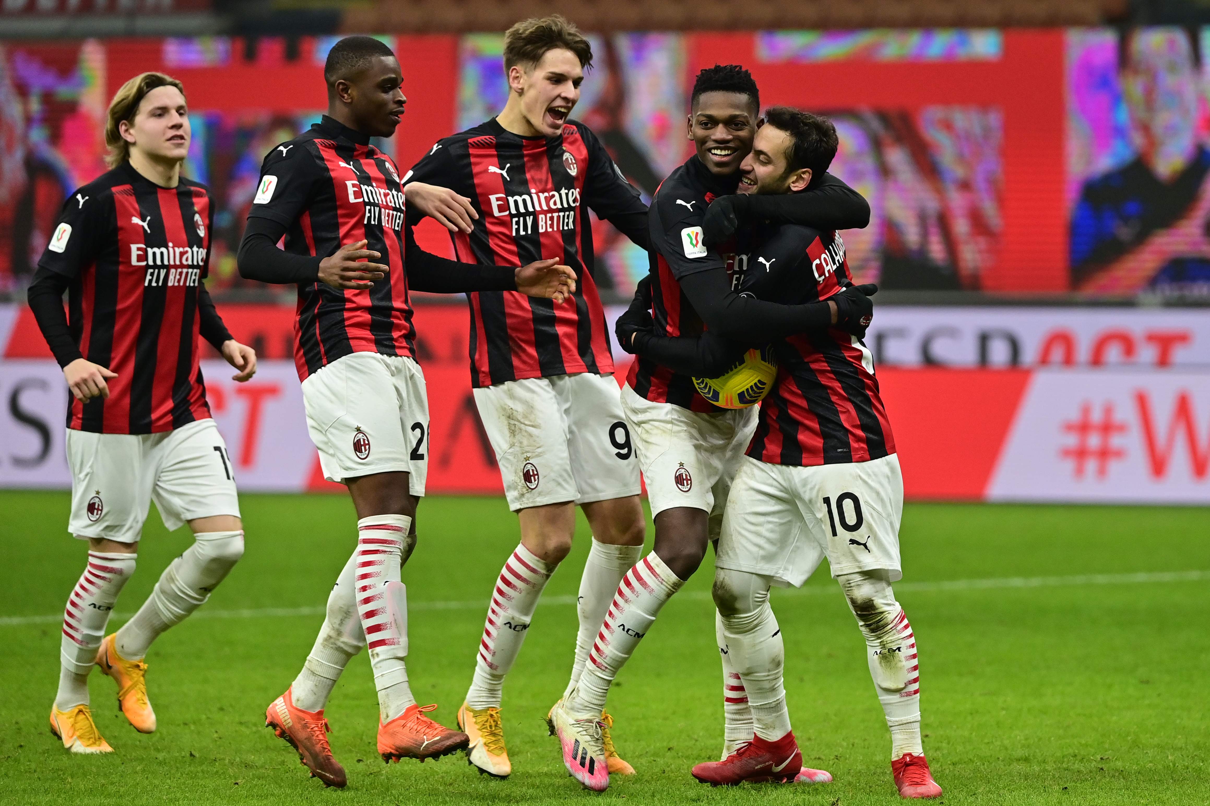 Para pemain AC Milan menyerbu Hakan Calhanoglu (kanan) yang menjadi algojo penentu adu penalti melawan Torino di laga Coppa Italia.