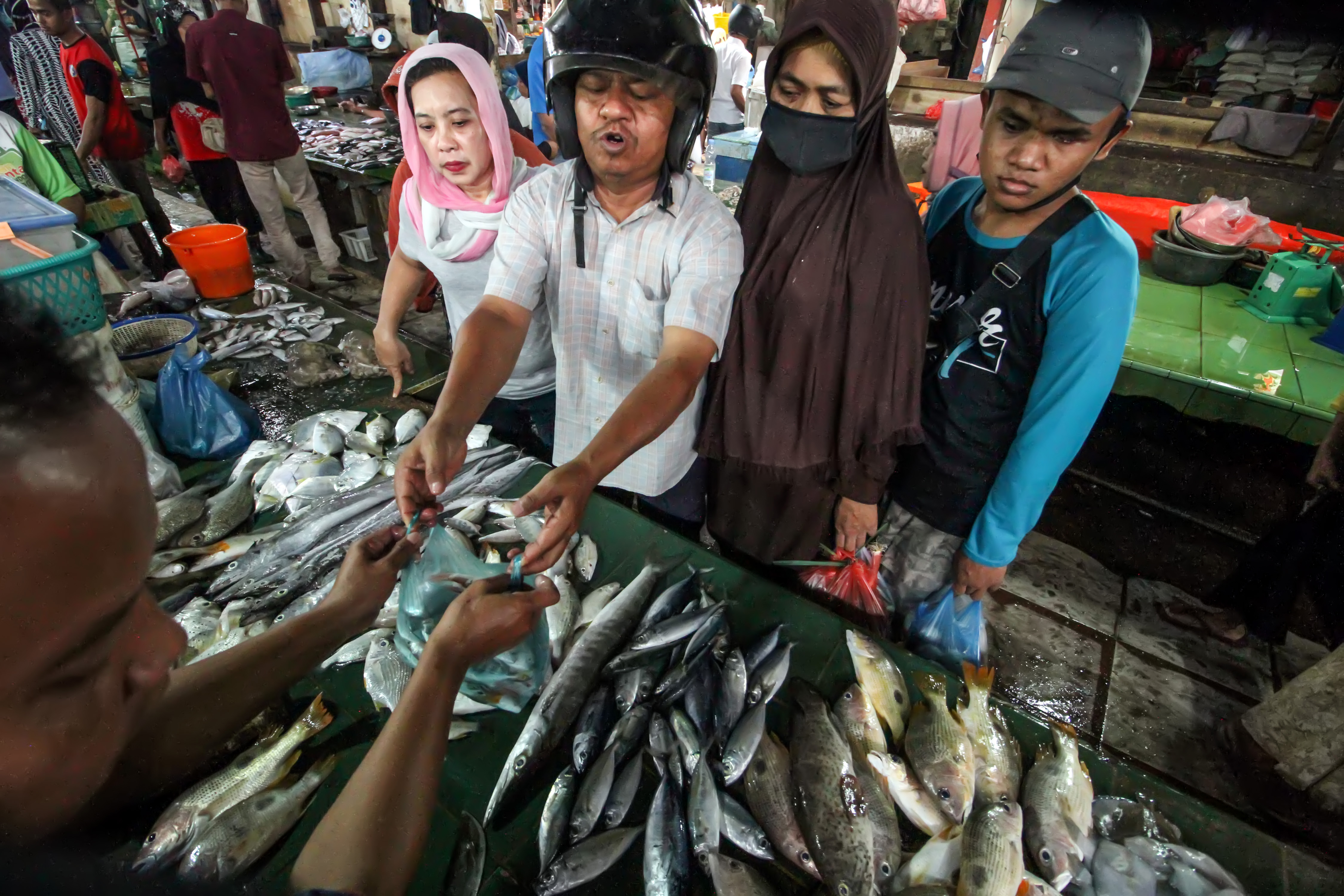 Pedagang melayani pembeli ikan segar di pasar tradisional Lhokseumawe, Aceh.