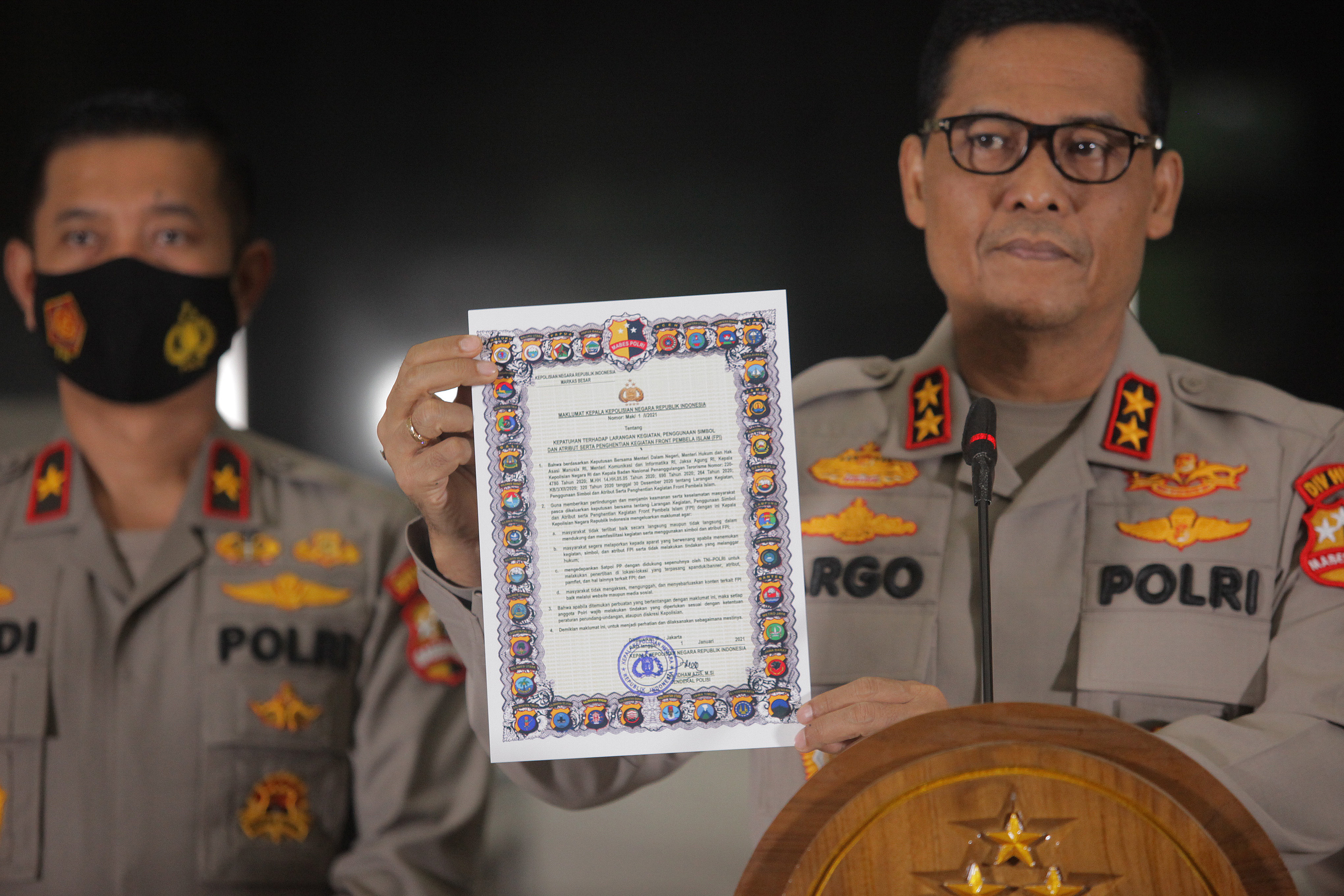 Kadiv Humas Polri Irjen Argo Yuwono (kanan) menunjukkan surat Maklumat Kapolri tentang Larangan Simbol FPI pada Jumat (1/1).