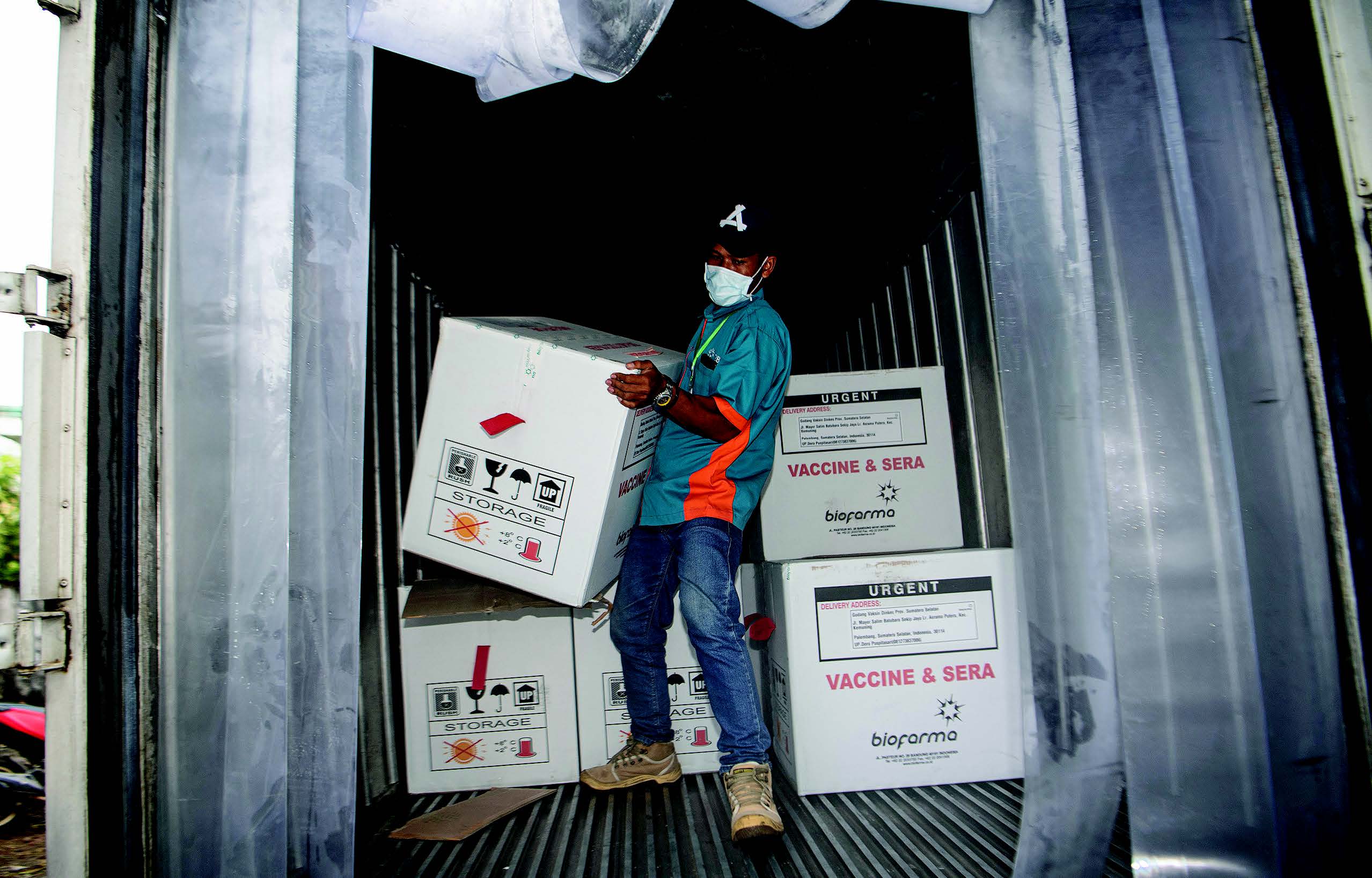 DISTRIBUSI VAKSIN COVID-19: Petugas memindahkan vaksin covid-19 Sinovac saat tiba di gudang vaksin (cold room)  