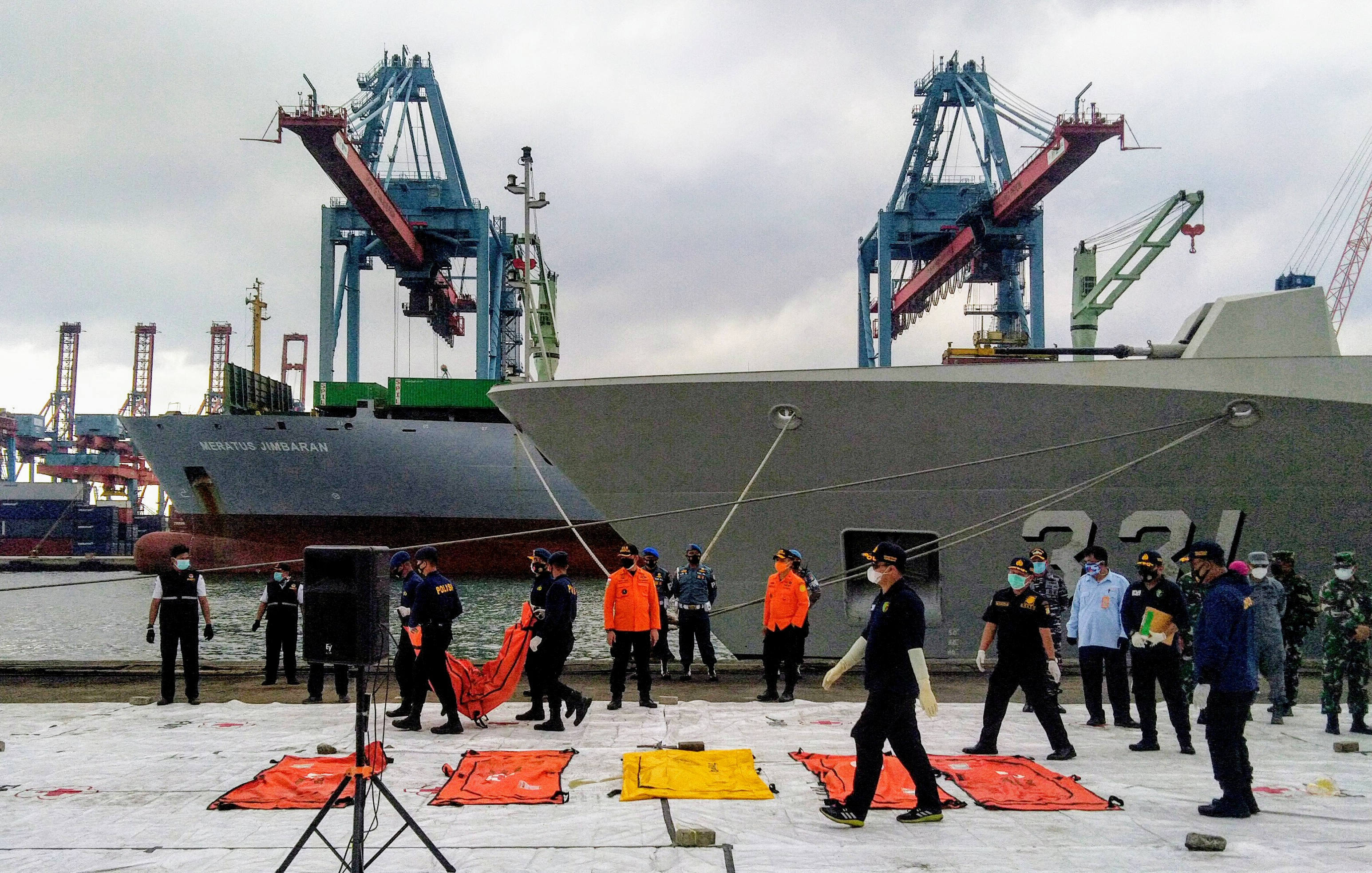 Petugas menurunkan kantong dari KRI Tenggiri yang membawa 6 kantong dari hasil pencarian pesawat Sriwijaya Air SJ-182.