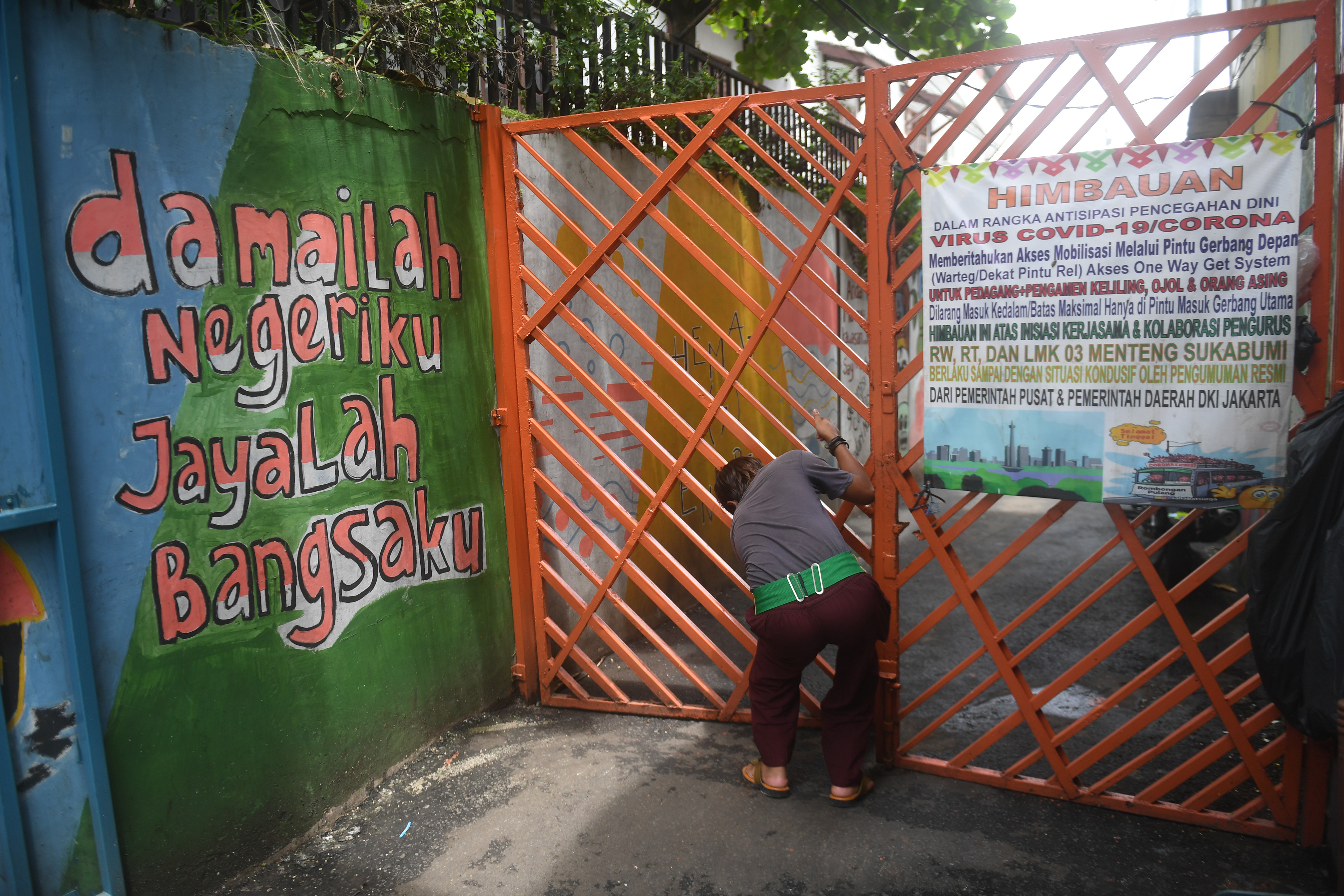Warga menutup pagar karantina wilayah saat pemberlakuan pembatasan kegiatan masyarakat (PPKM) skala mikro di kawasan Menteng