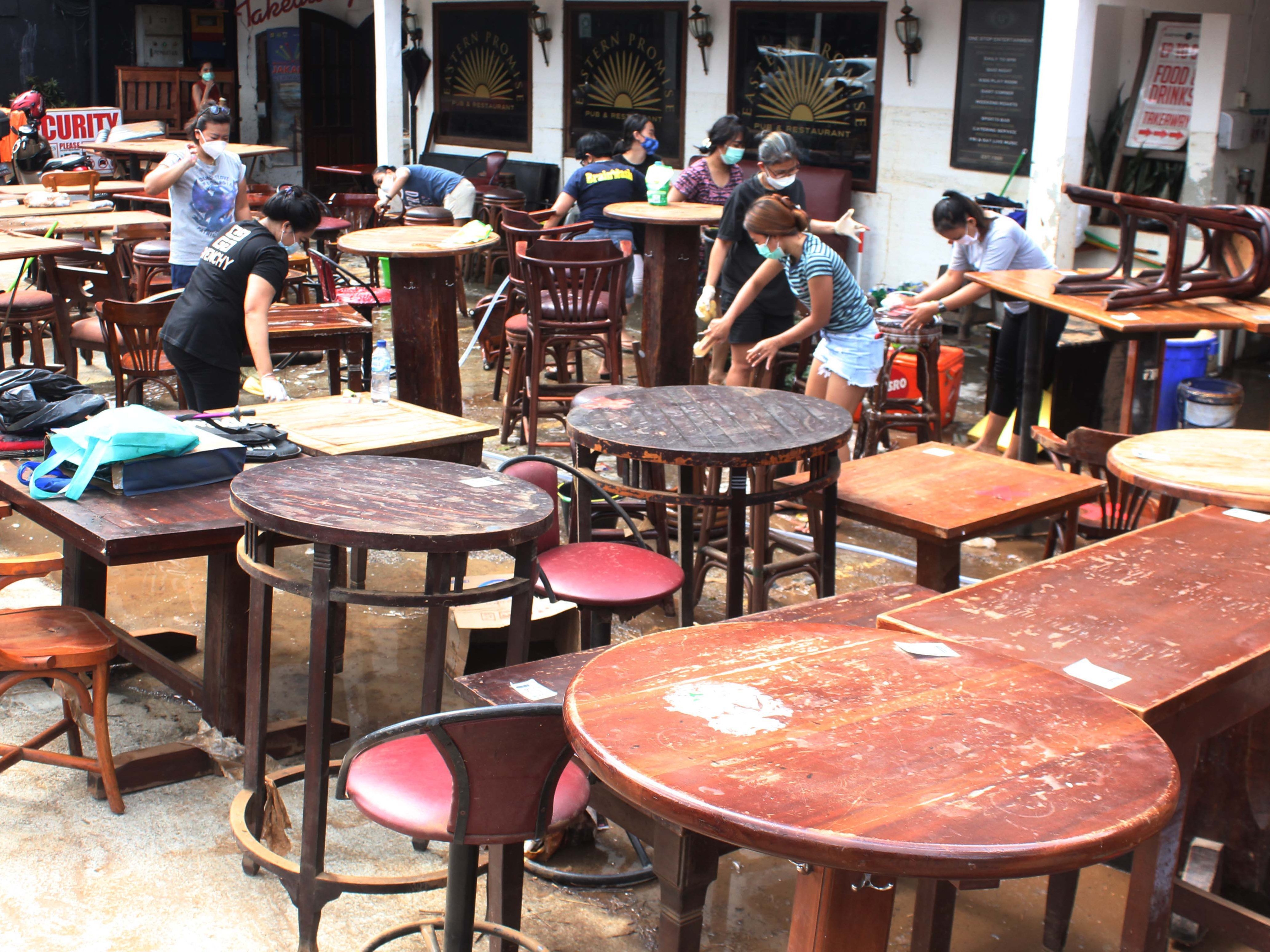 Para karyawan membersihkan barang-barang yang terendam banjir di Kemang, Jakarta Selatan, Minggu (21/2).