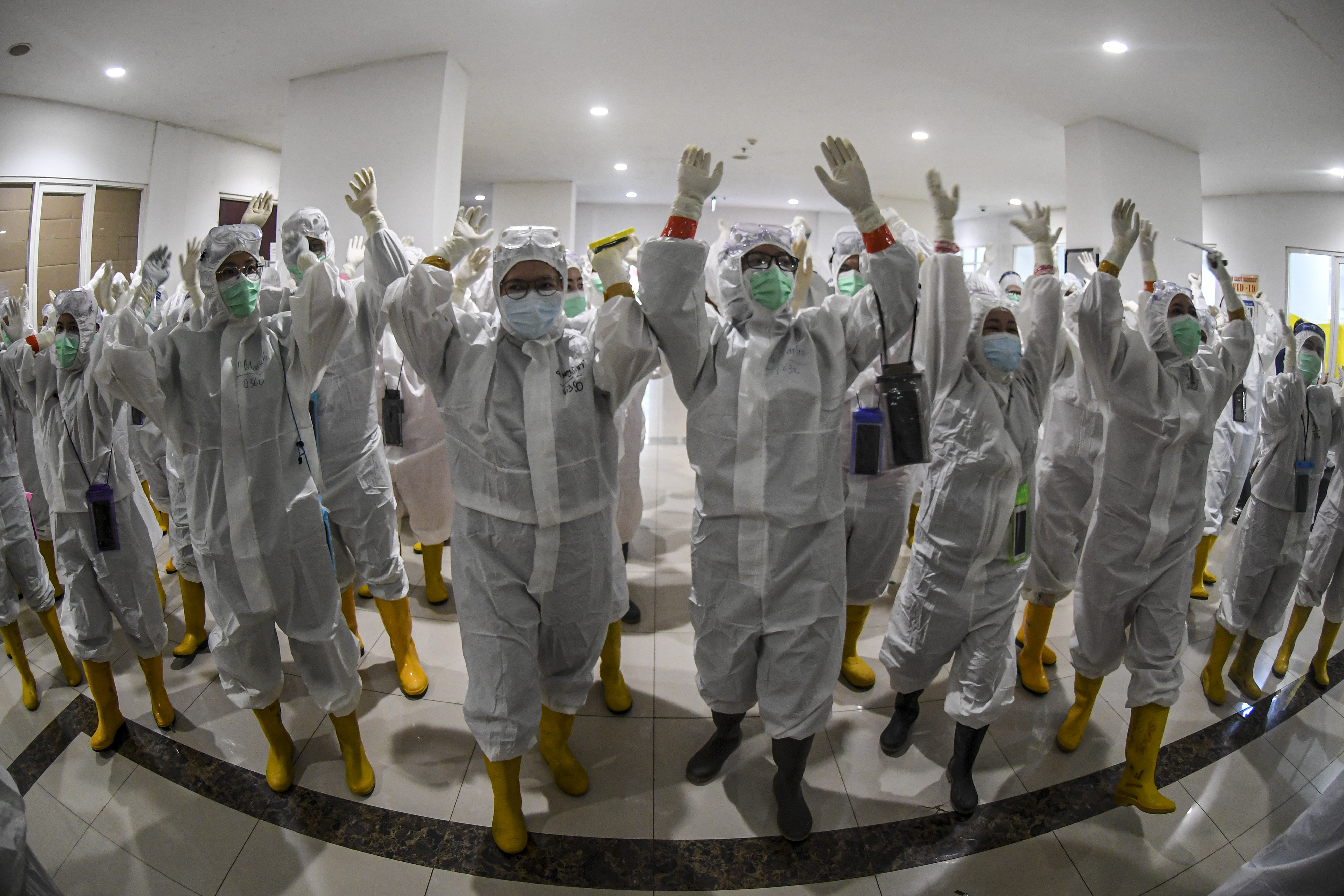 Sejumlah tenaga kesehatan meneriakan yel-yel sebelum pergantian jadwal perawatan pasien covid-19 di RSD Wisma Atlet Kemayoran, Jakarta.