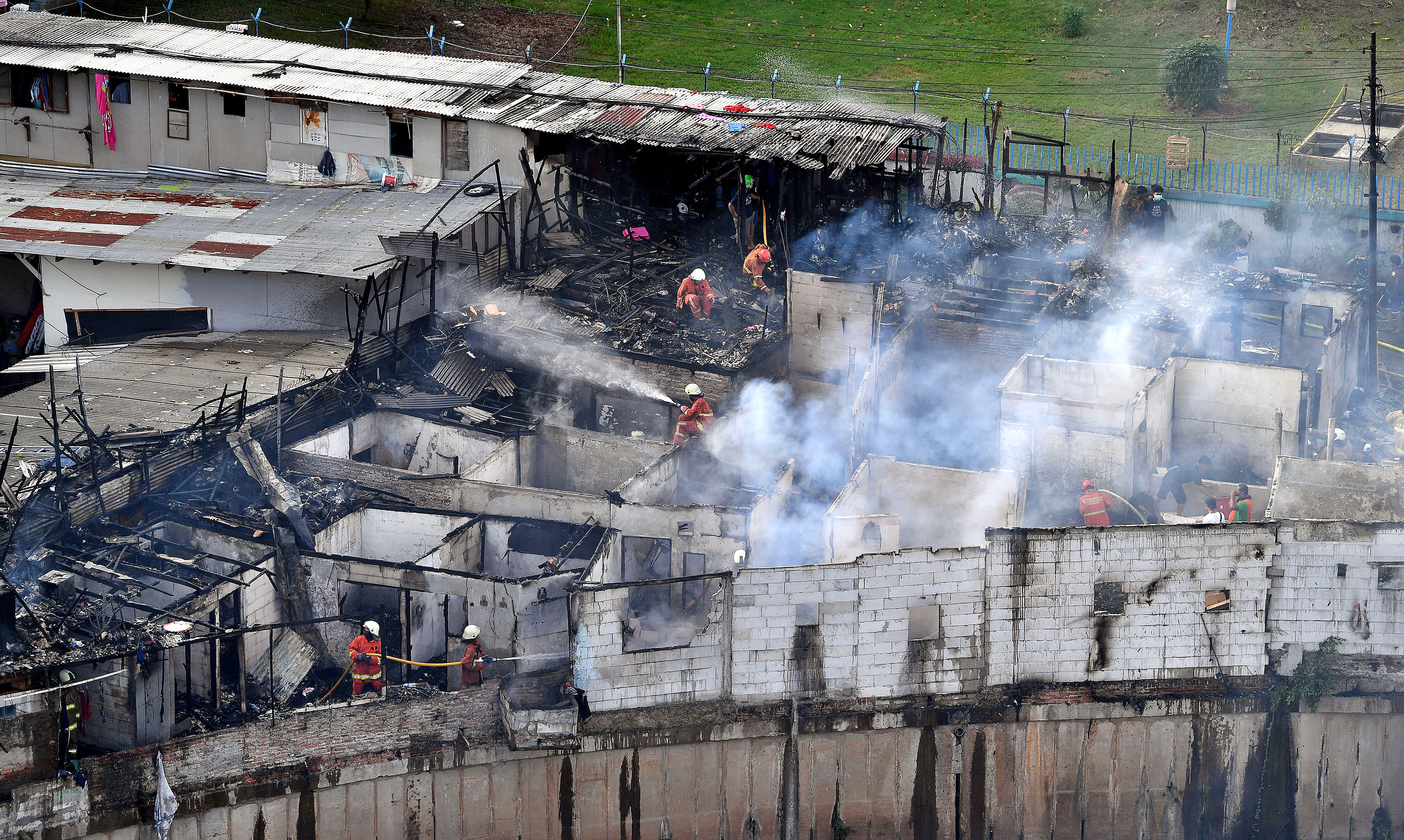 Pemadam kebakatan mendinginkan sisa api bekas kebakaran pemukiman di Bendungan Hilir, Desember 2020