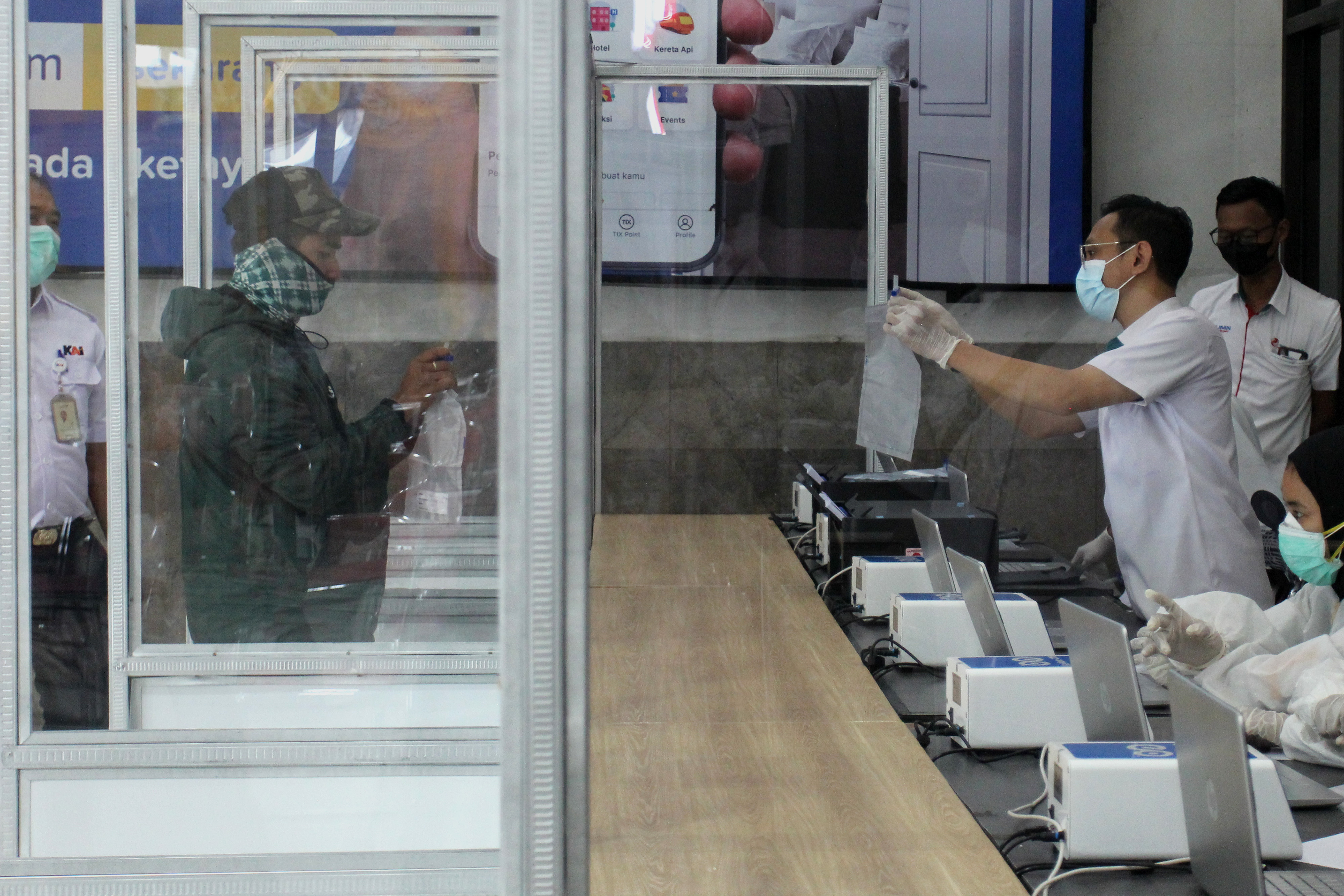 Petugas Stasiun Pasar Turi, Surabaya, Senin (15/2) menjelaskan kepada calon penumpang tes deteksi Covid-19 dengan metode GeNose C-19.