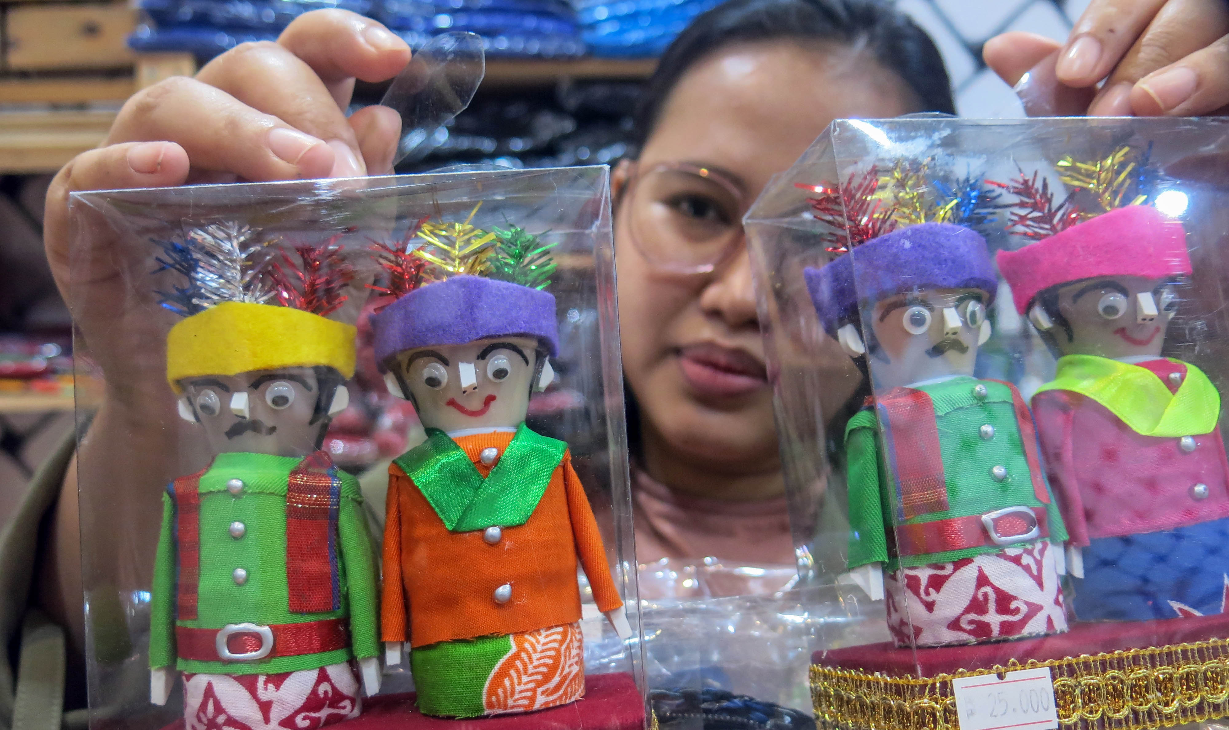 Pekerja menunjukkan miniatur ondel-ondel yang telah selesai dibuat di Betawi Online Galeri, Setu Babakan, Jakarta Selatan, Selasa (2/2/2021