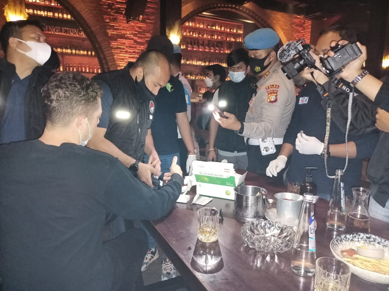 Petugas gabungan melakukan razia prokes di Kafe Brotherhood, Jakarta.