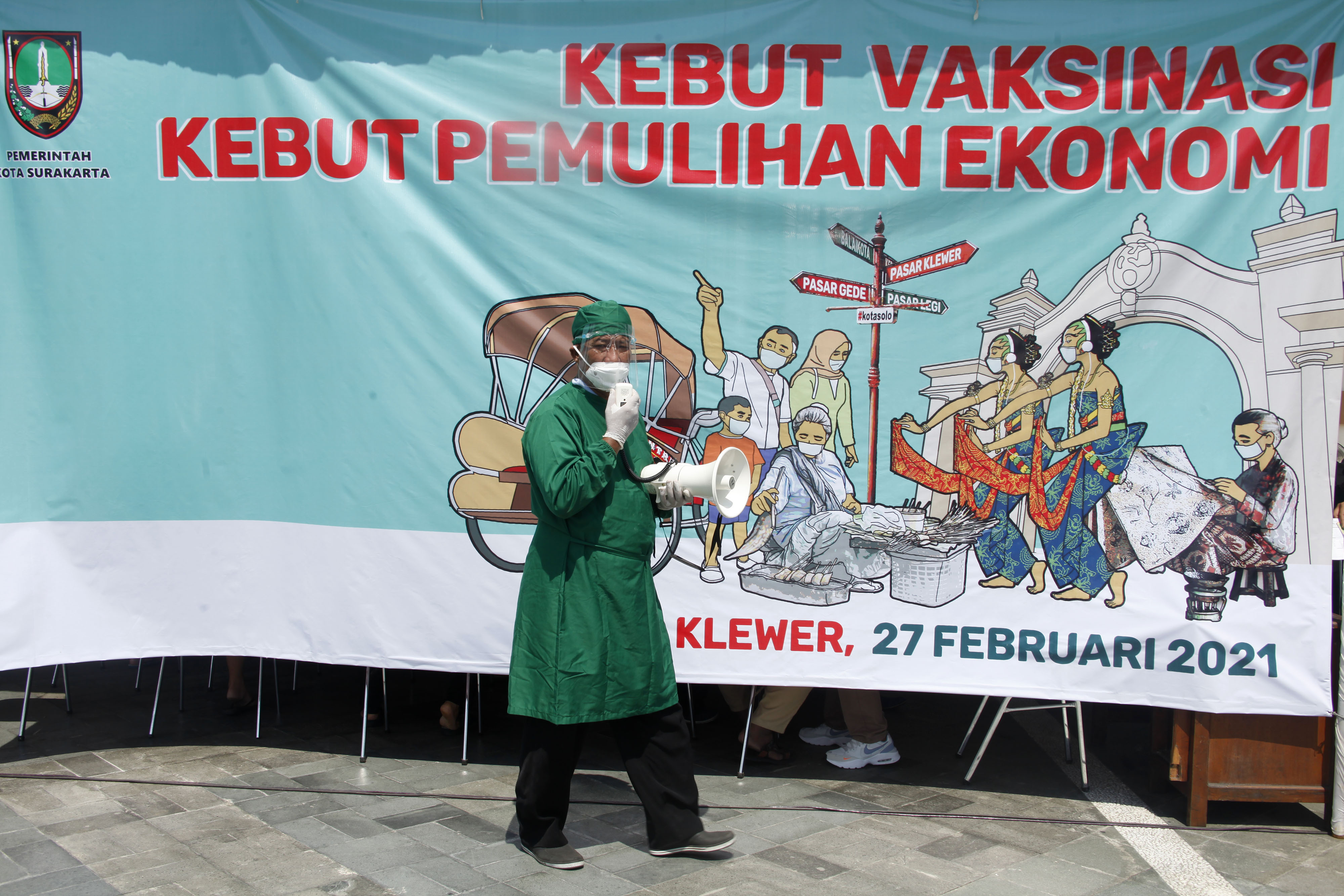 Petugas mengumumkan aturan pelaksanaan vaksin COVID-19 untuk pedagang saat vaksinasi di Pasar Klewer, Solo, Jawa Tengah, Sabtu (27/2/2021).