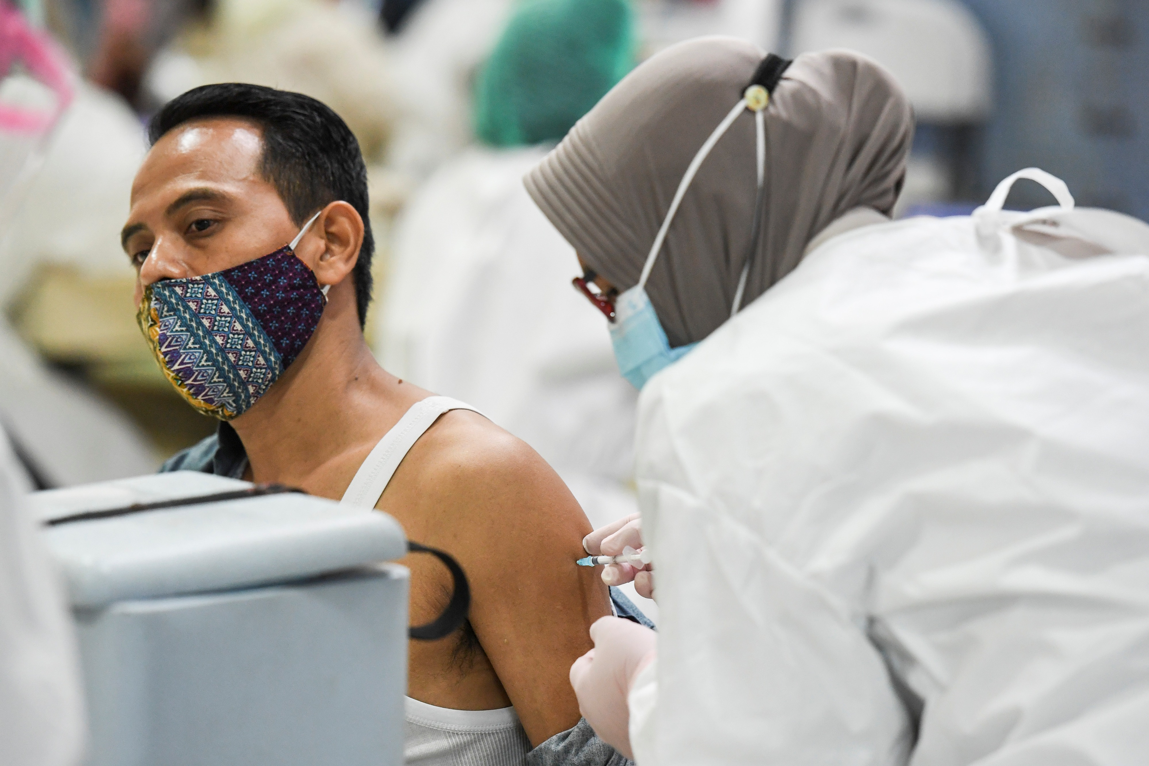 Petugas menyuntikkan vaksin covid-19 kepada pedagang di Pasar Tanah Abang Blok A, Jakarta, Rabu (17/2).