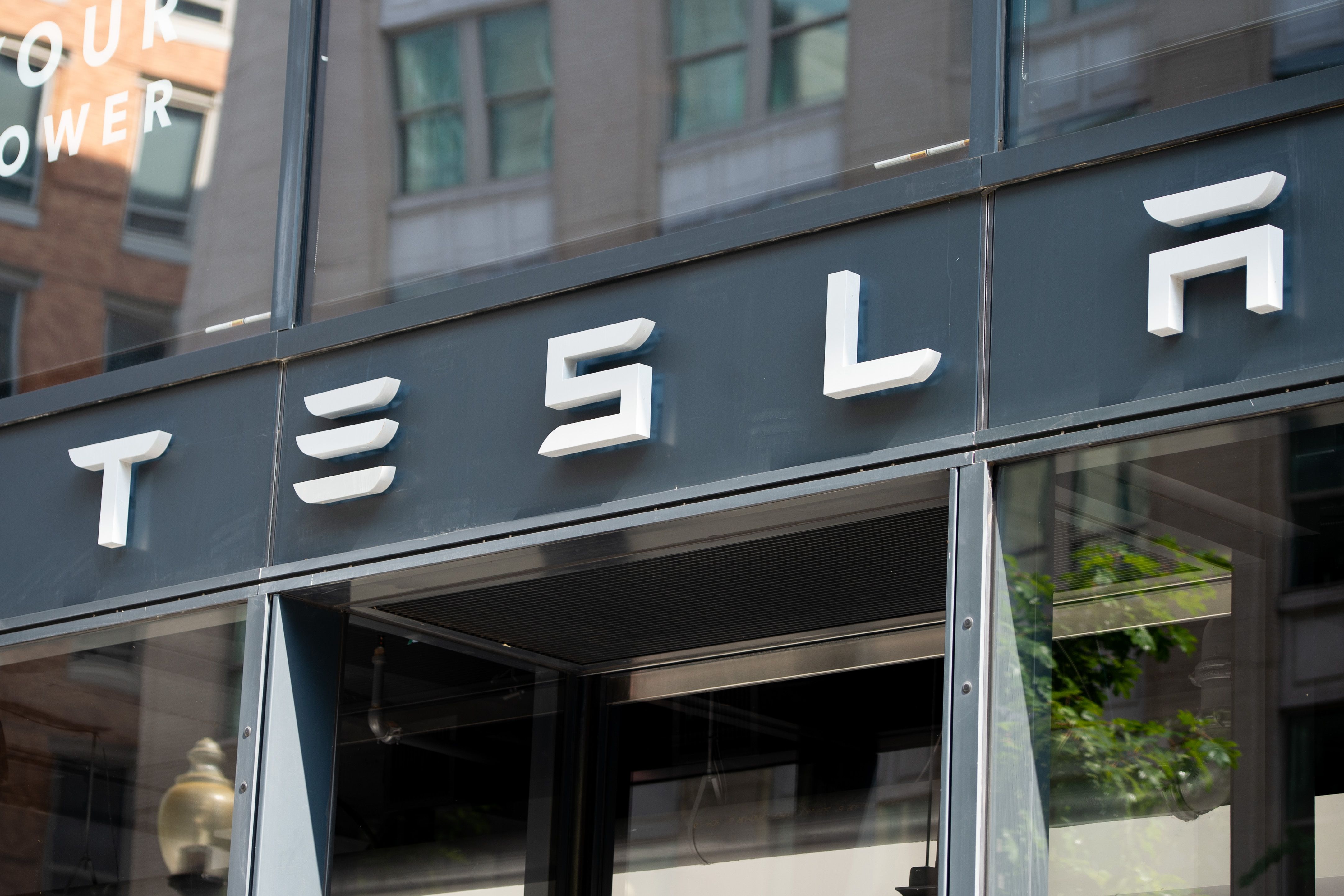 Logo Tesla yang terpasang di sebuah showroom di Washington DC, Amerika Serikat.