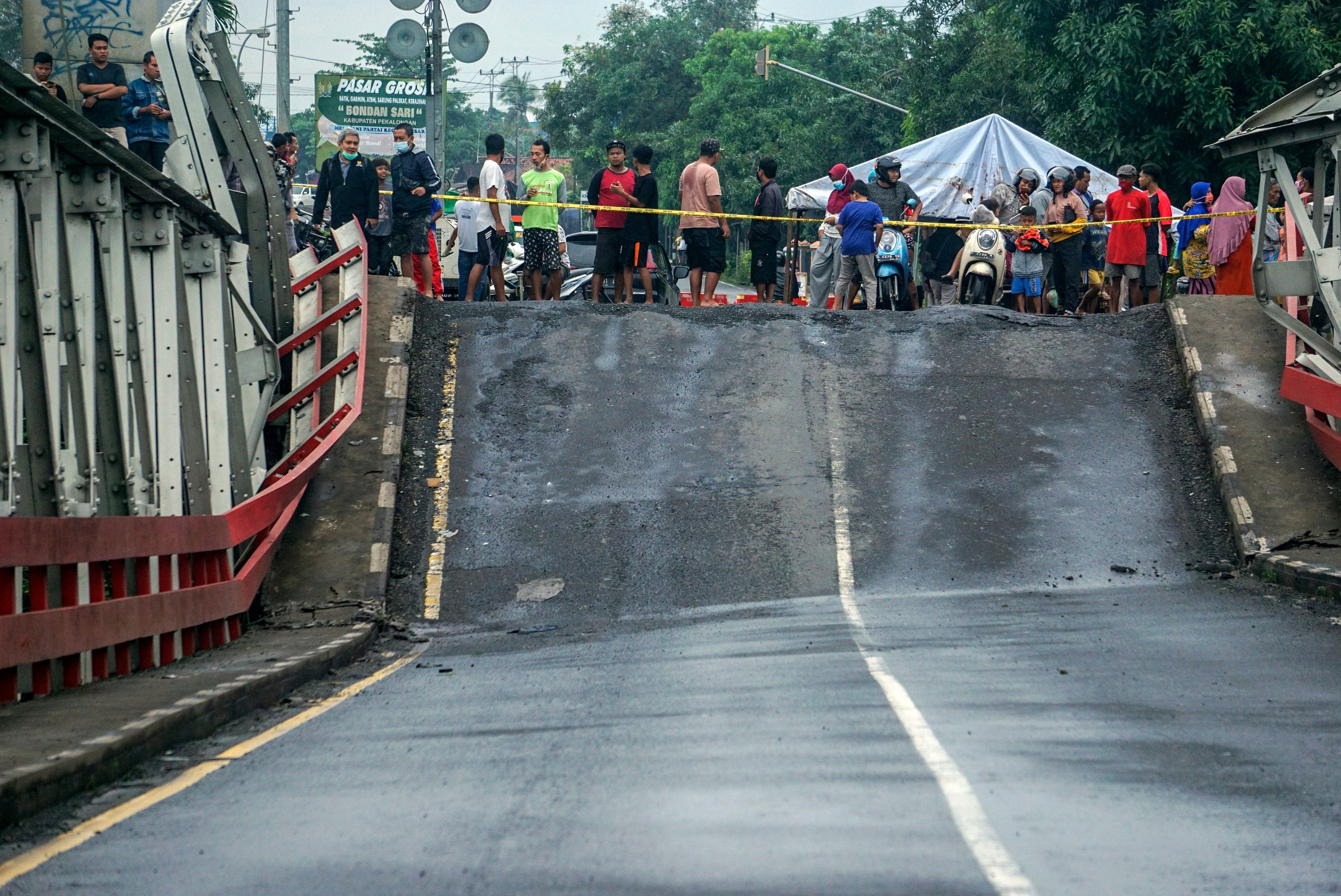Warga melihat jembatan perbatasan yang amblas di Kabupaten Pekalongan, Jawa Tengah.