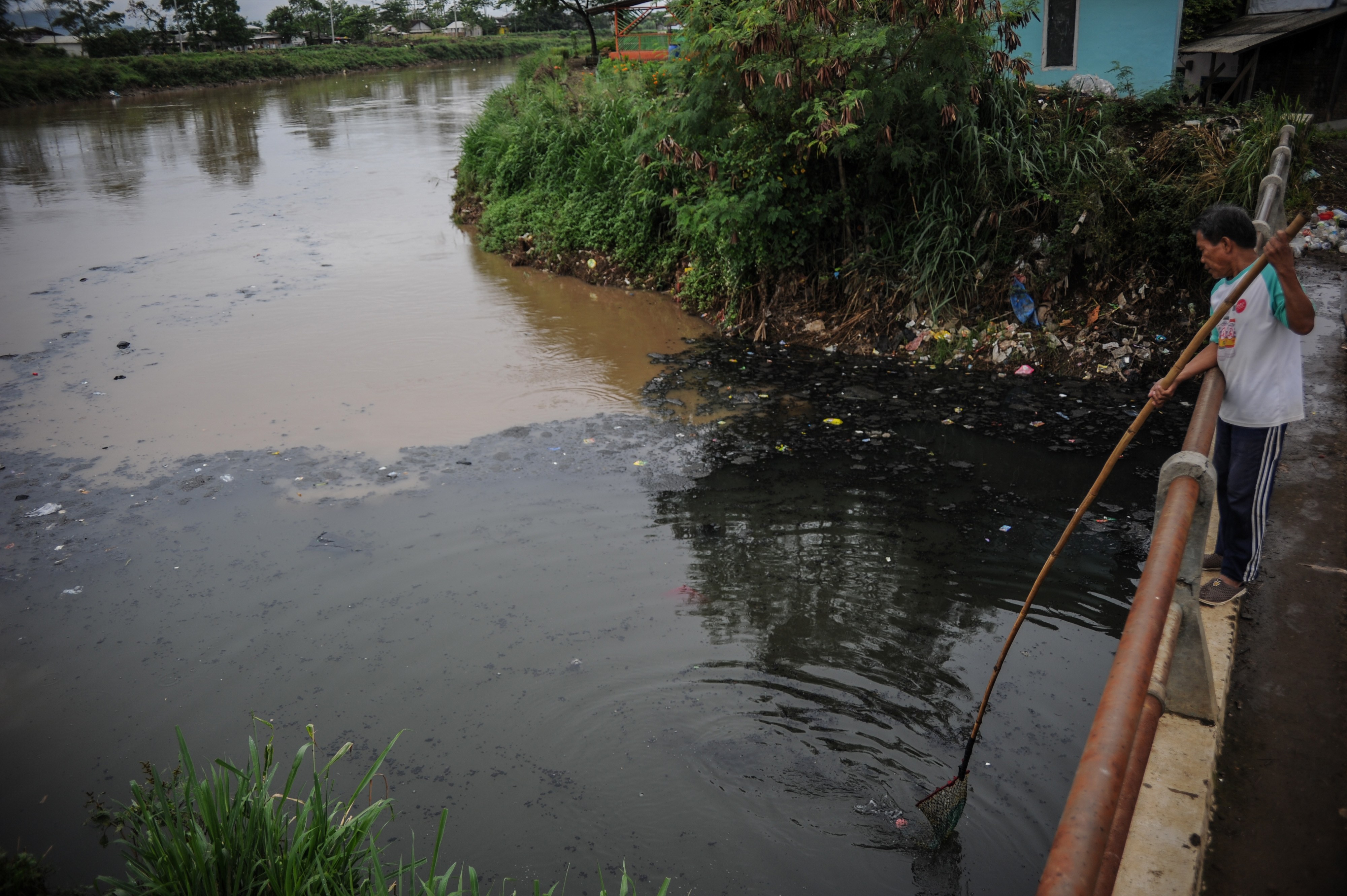 Warga mengambil sampah di muara pertemuan antara Sungai Citepus dan Sungai Citarum yang tercemar limbah