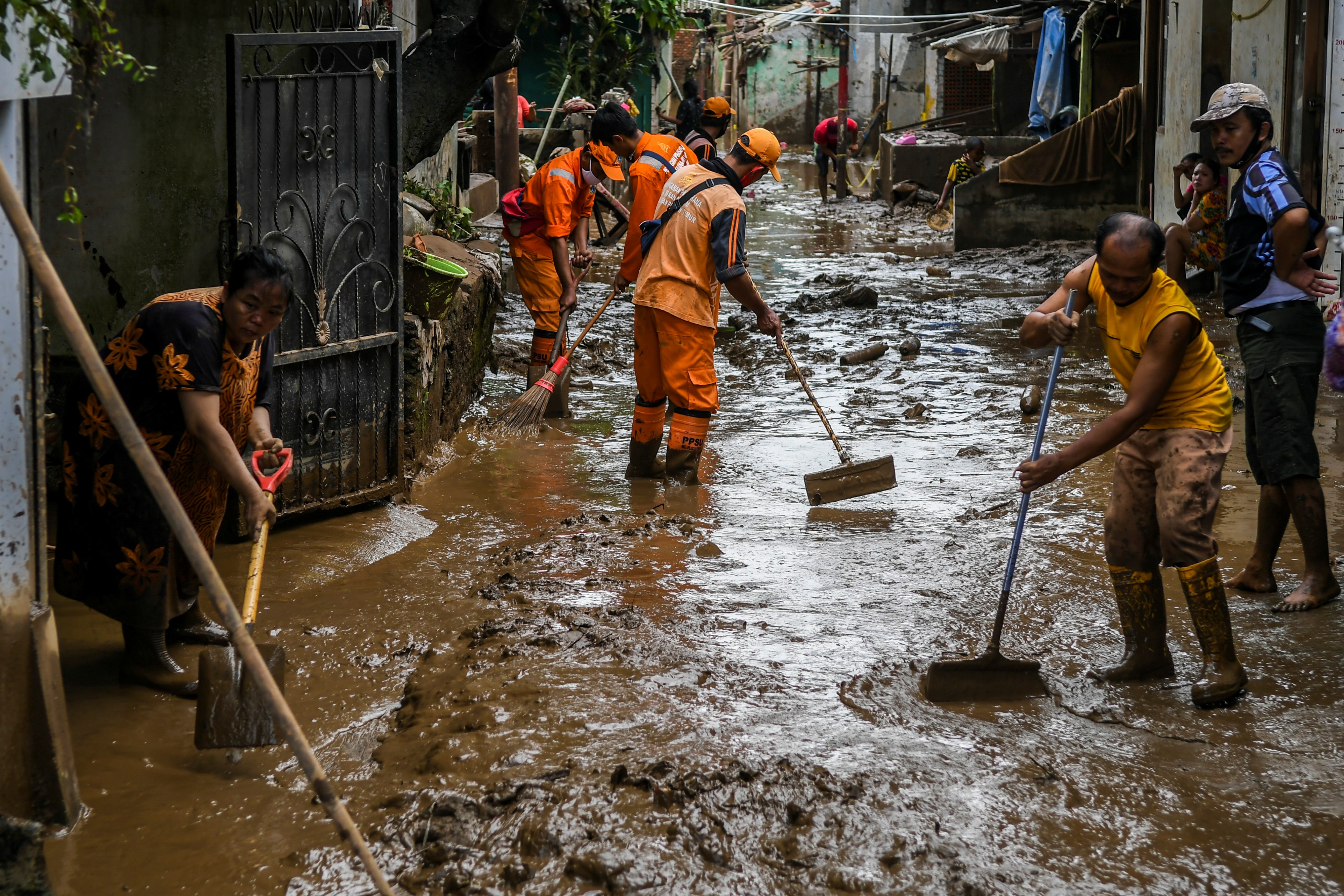 Warga bersama petugas kebersihan membersihkan endapan lumpur sisa banjir di kawasan Pejaten Timur, Jakarta, beberapa waktu lalu.