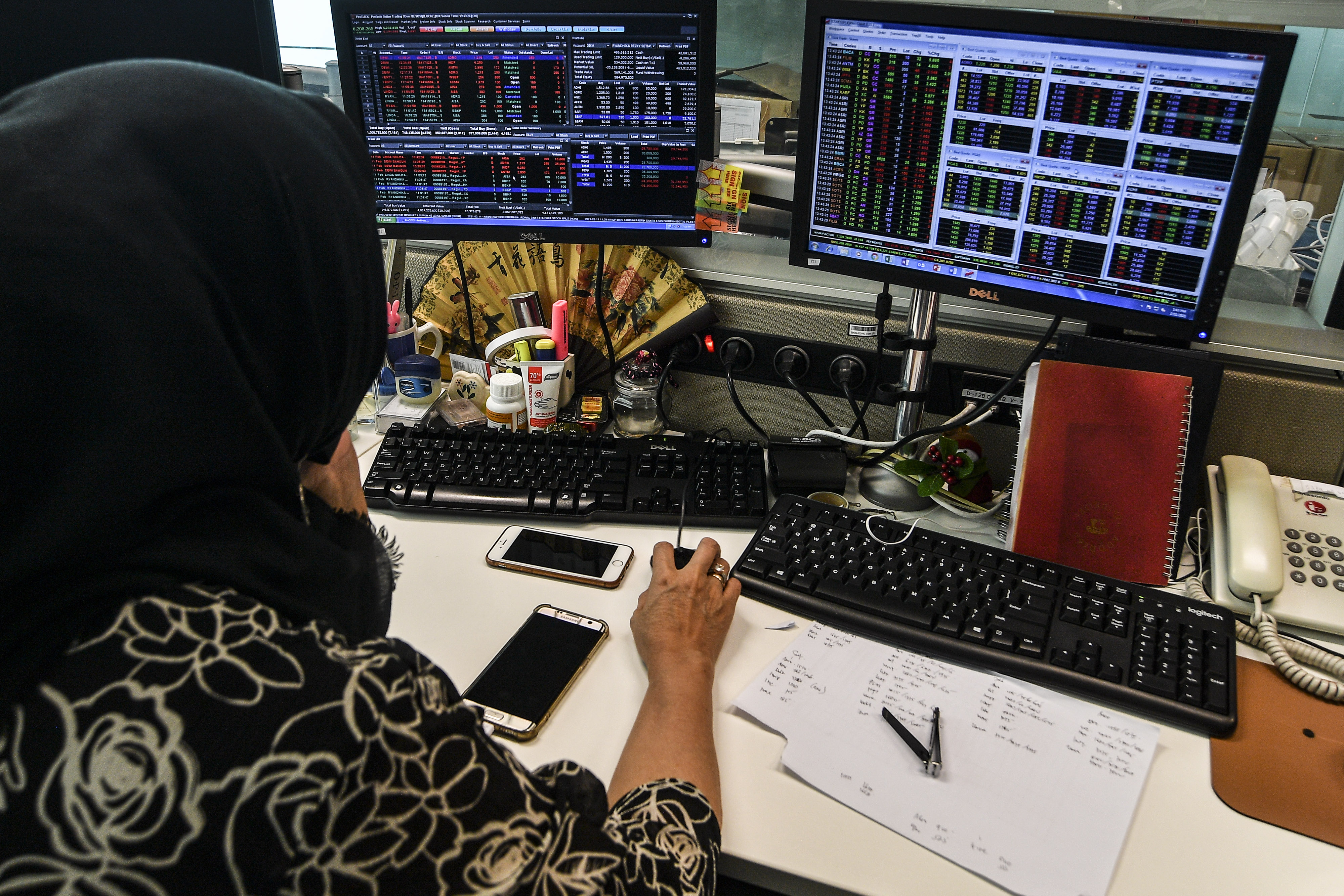 Karyawan mengamati pergerakan harga saham di Jakarta, Kamis (11/2/2021)