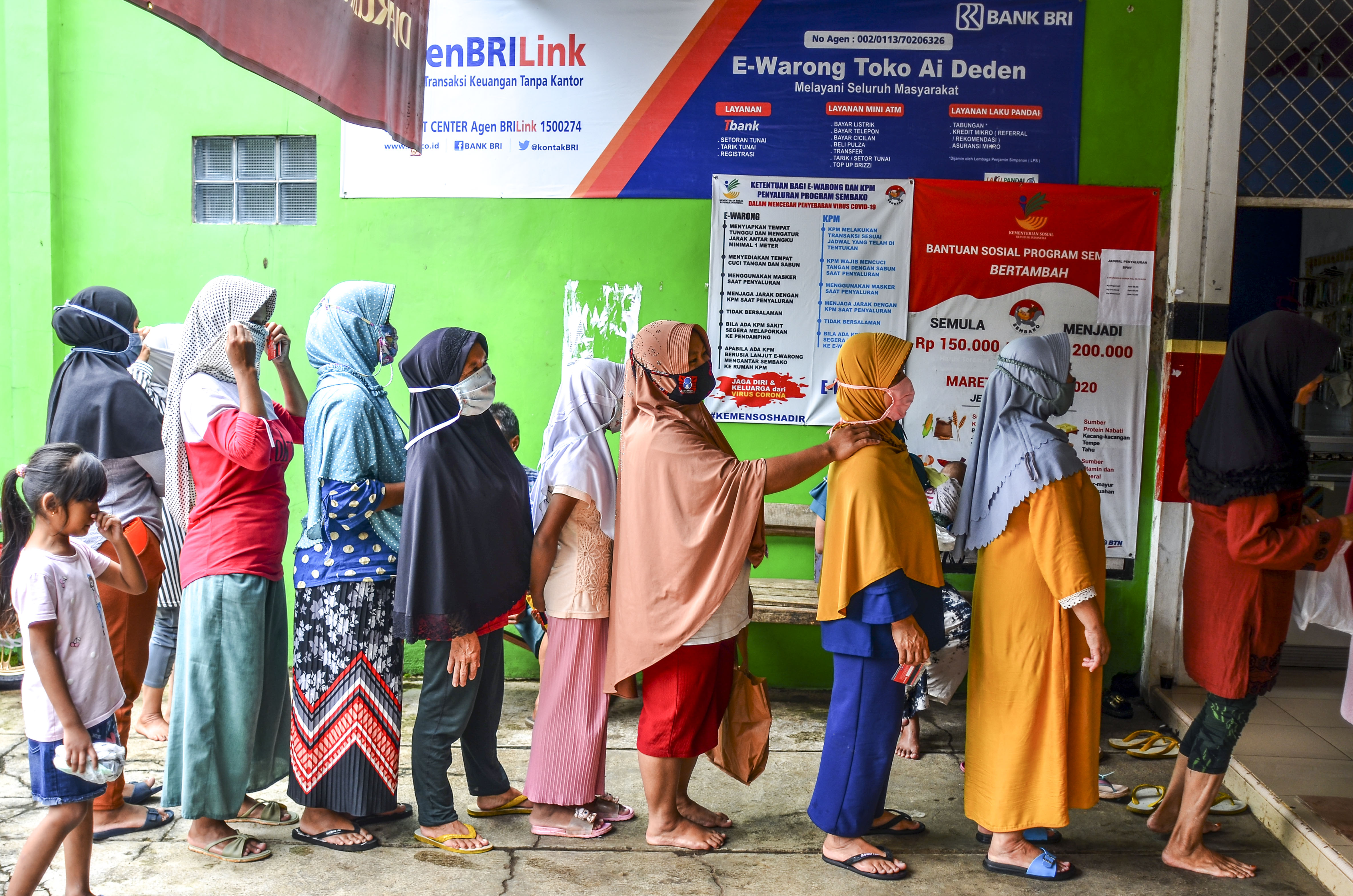 Warga mengantre saat pencairan bantuan sosial non tunai di Desa Tanjungsari, Kecamatan Sukaresik, Kabupaten Tasikmalaya, Jawa Barat