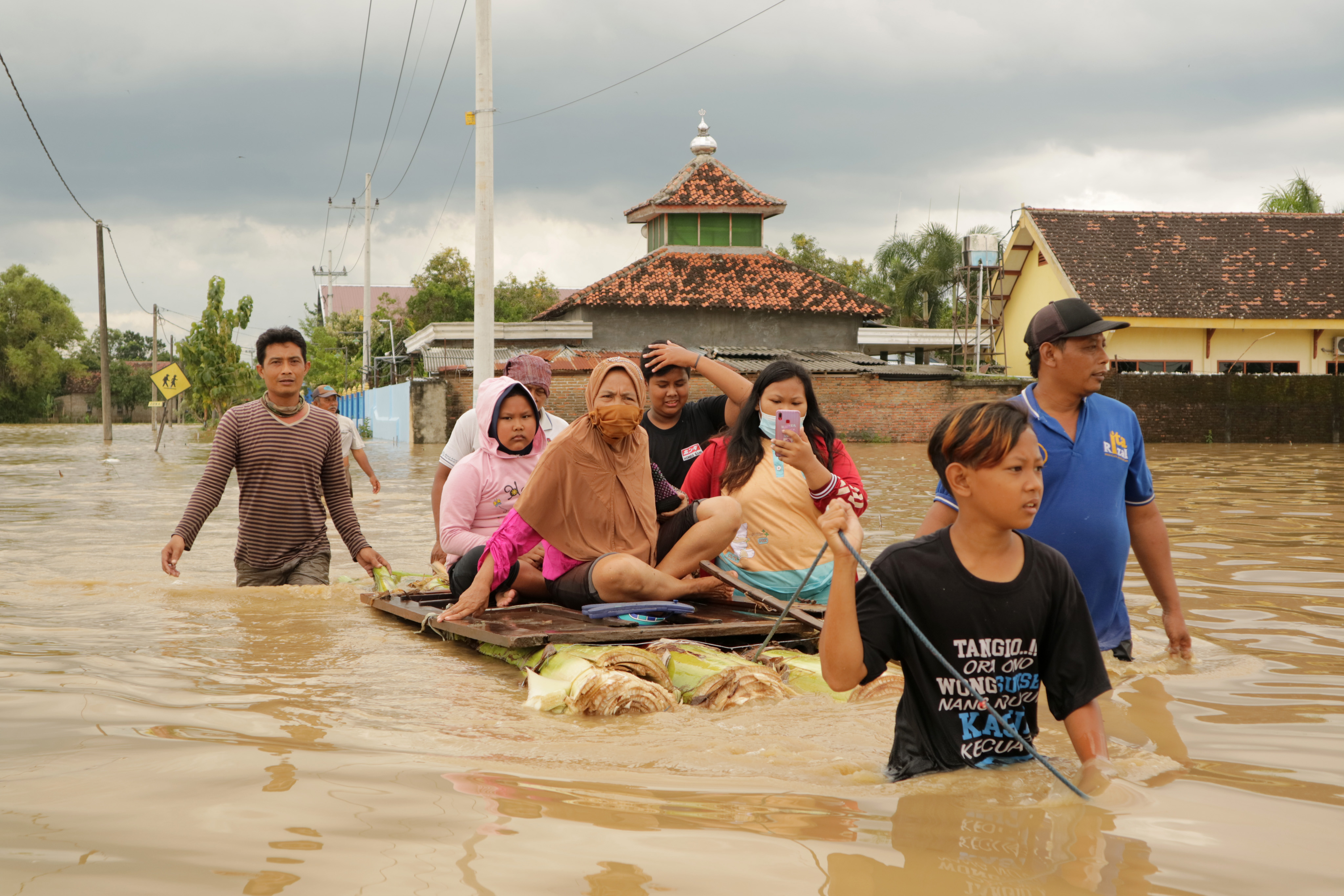 BANJIR: Warga menaiki sampan darurat saat banjir menggenangi Dusun Manisrenggo, Kecamatan Bandar Kedungmulyo, Kabupaten Jombang, Jatim.