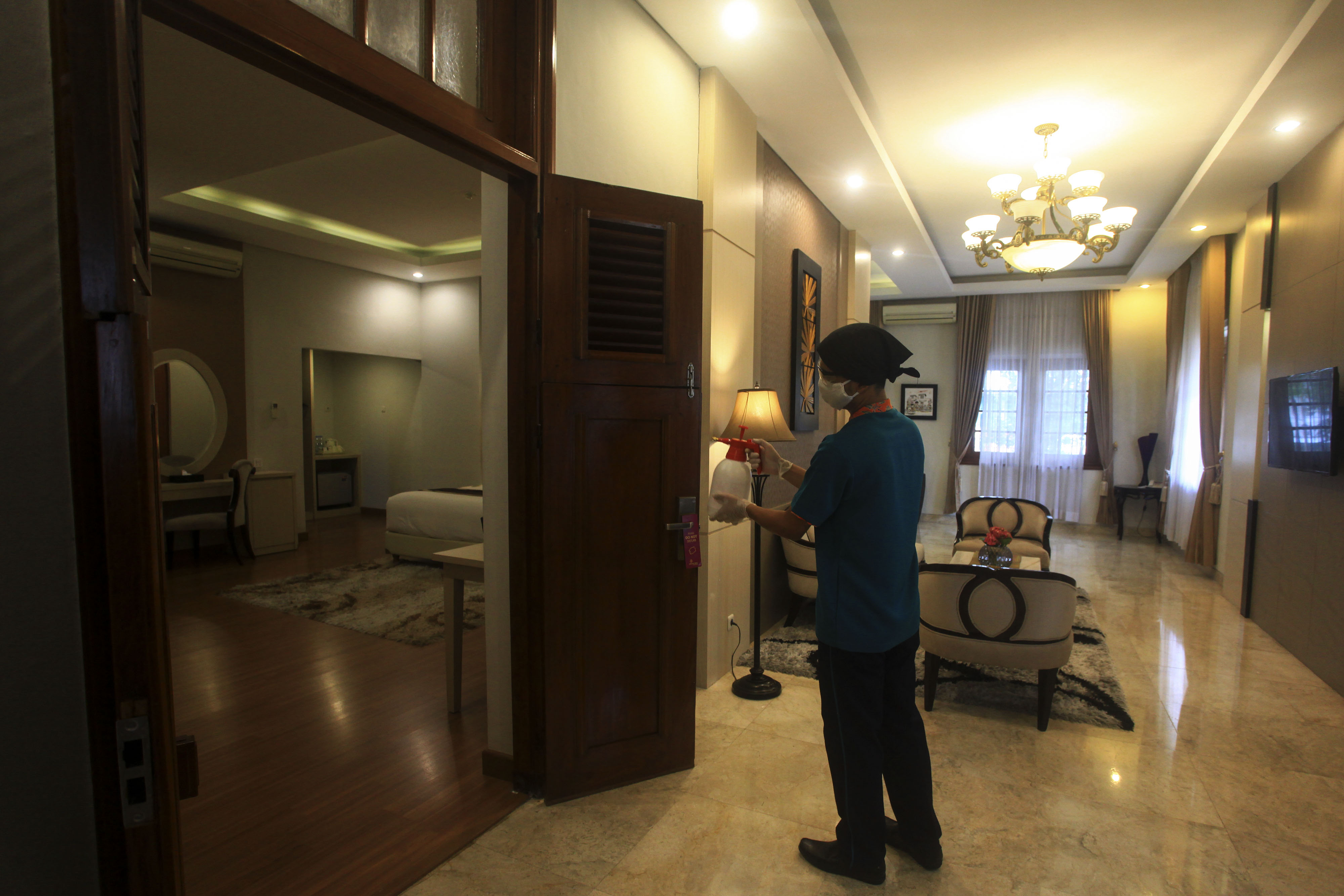 Pekerja membersihan kamar dengan disinfektan di sebuah hotel di Yogyakarta.