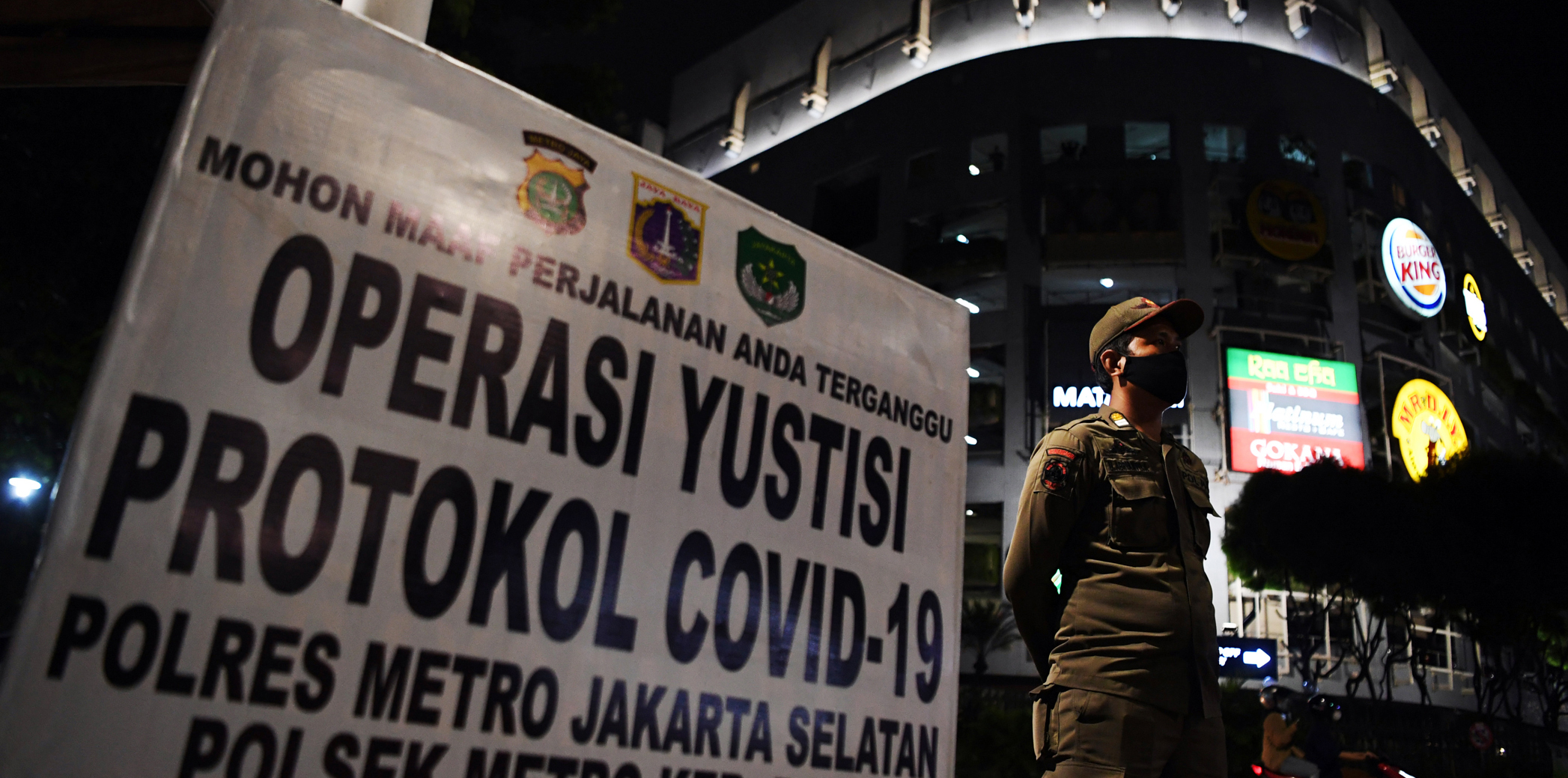 Petugas Satpol PP berjaga saat Operasi Yustisi protokol kesehatan covid-19 di kawasan Bundaran Bulungan, Blok M, Jakarta.