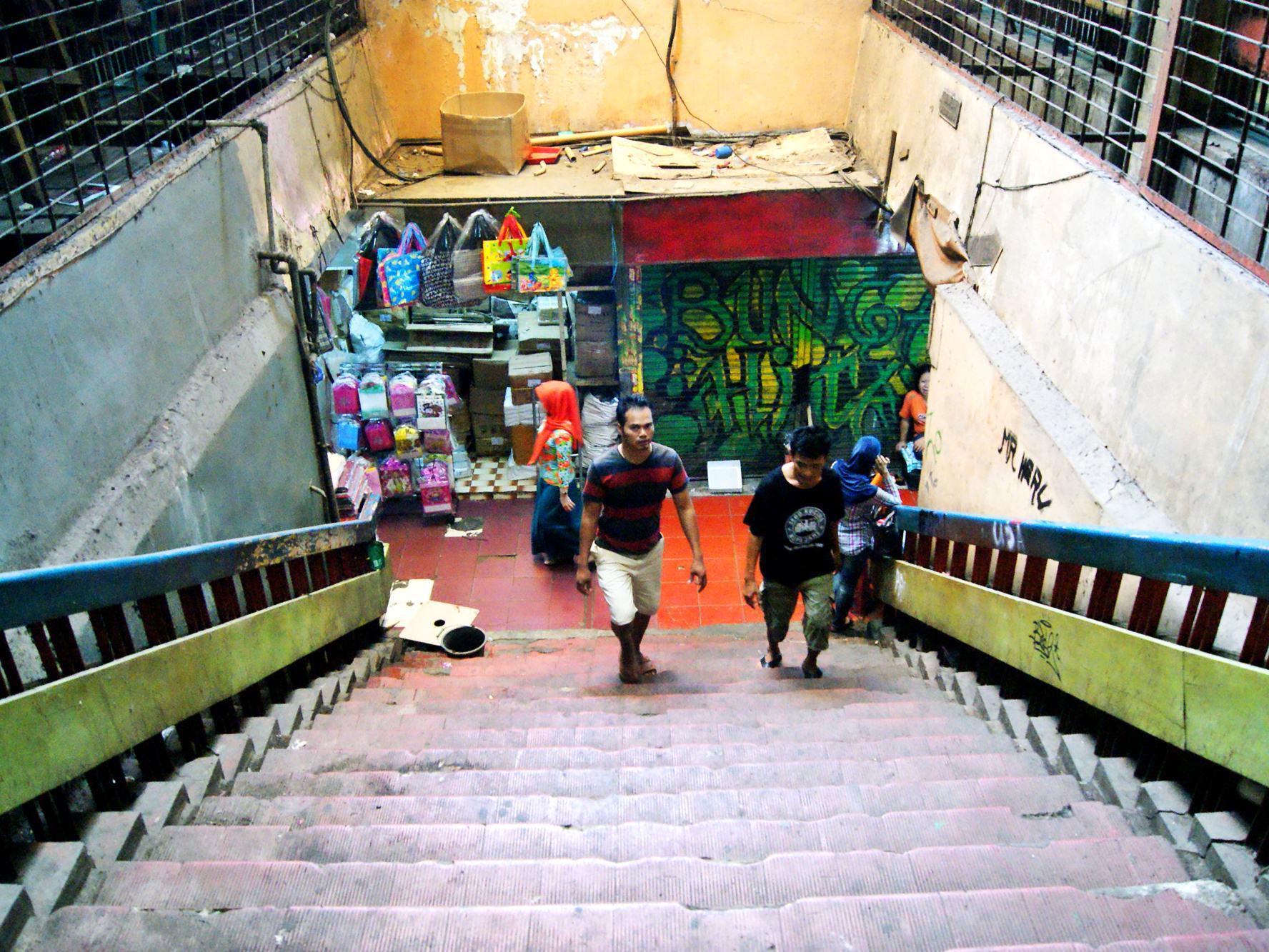 Dua orang menaiki tangga di pasar tradisional, Jakarta.