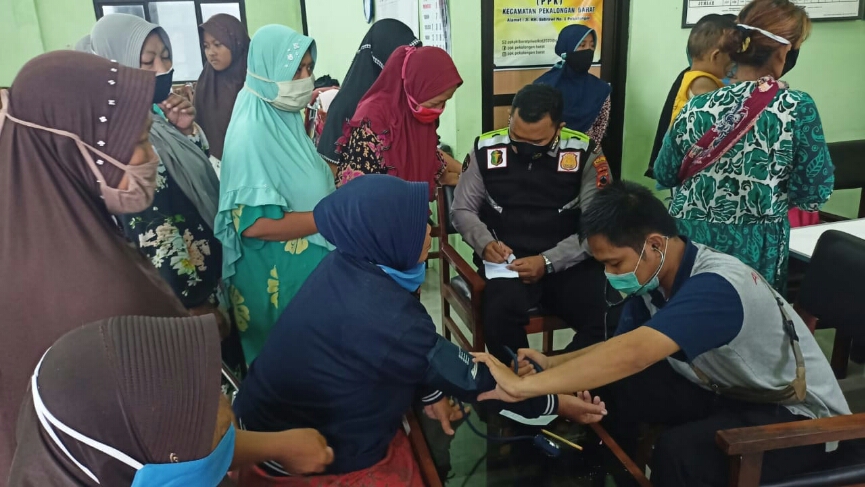 Warga terdampak banjir sedang didata dan diperiksa kesehatannya oleh petugas dan relawan.